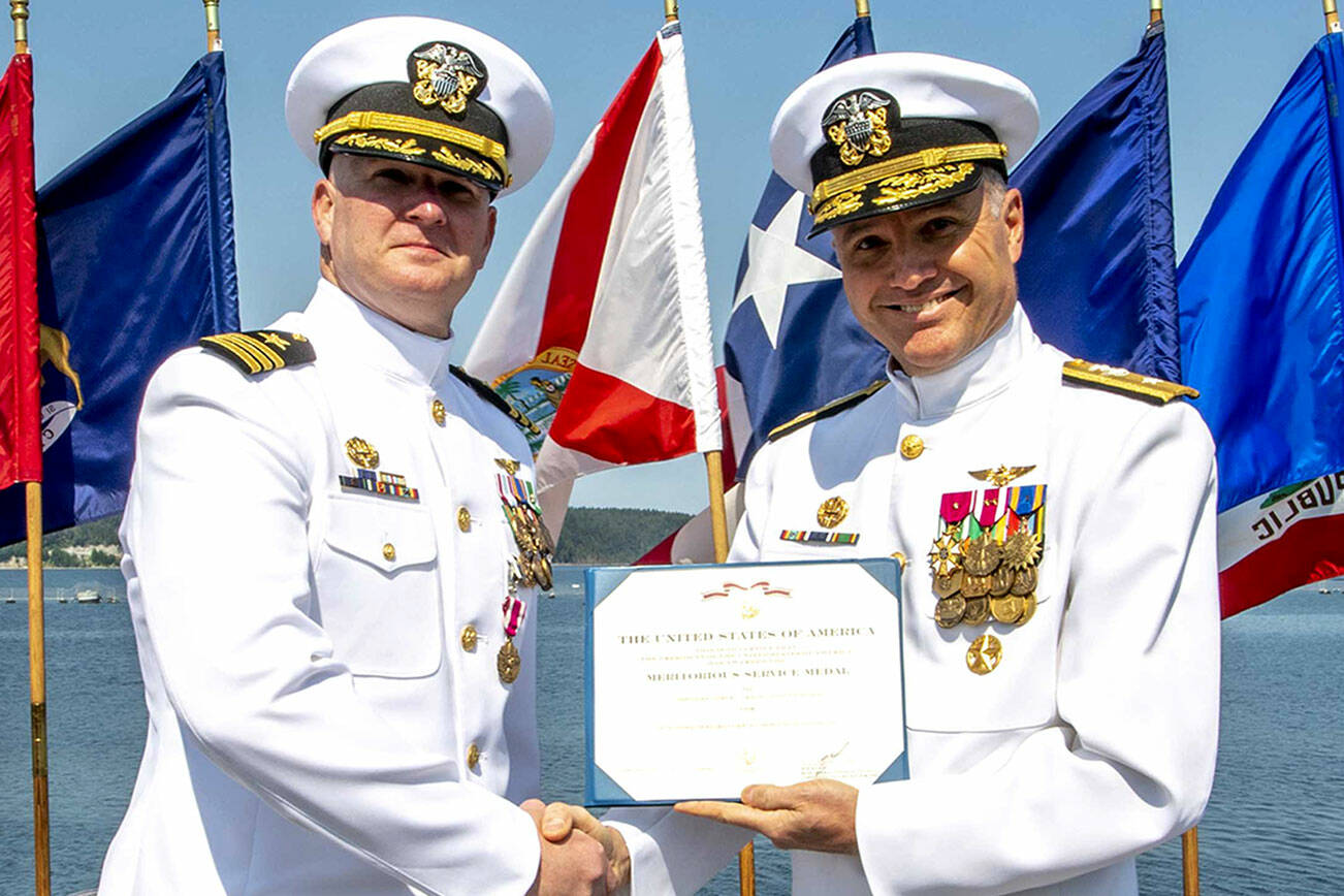 Navy Region Northwest Rear Admiral Mark Sucato, far right, shakes the hand of Cmdr. Todd Galvin as he takes command of Naval Magazine Indian Island.