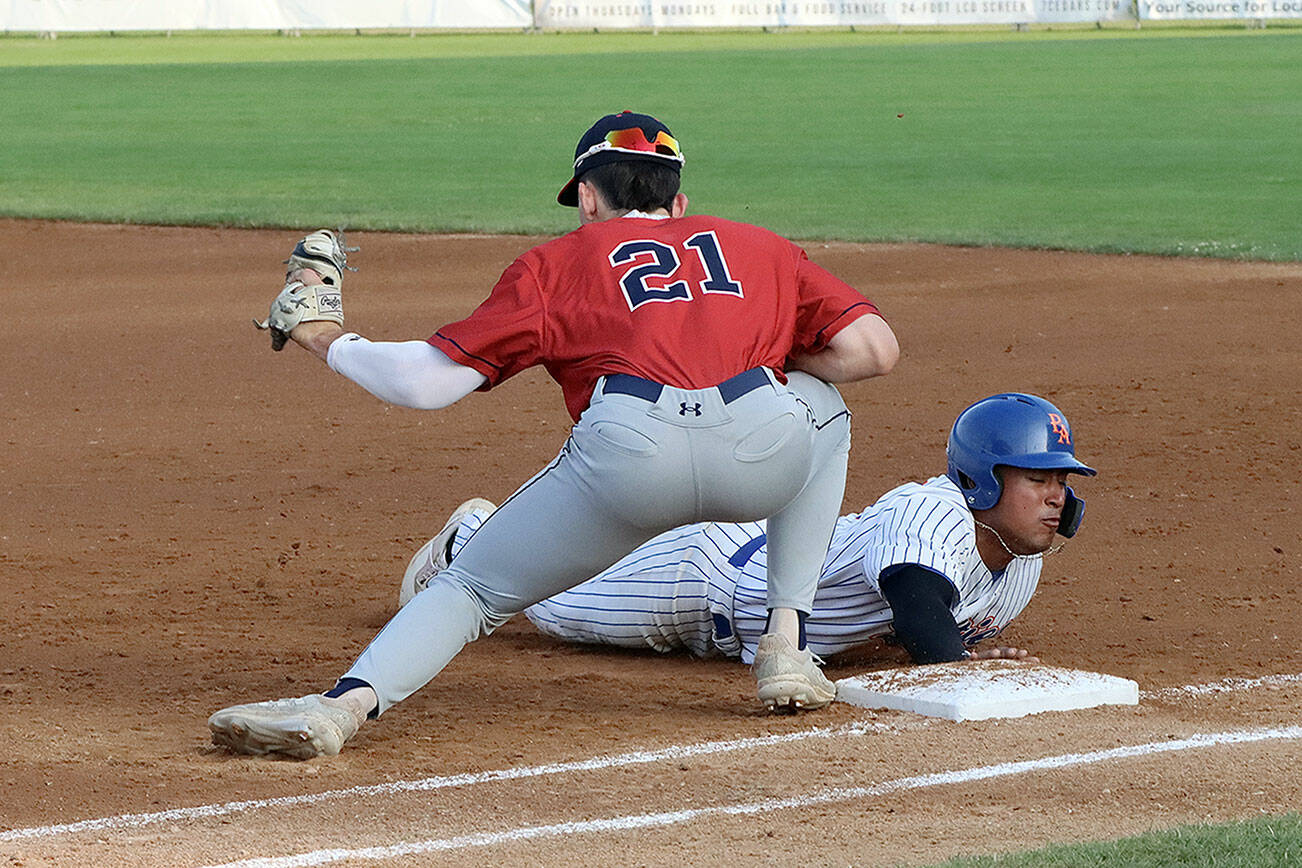 Dave Logan/for Peninsula Daily News
Port Angeles' Roberto Nunez III slides safely back to first base as Wenatchee's Easton Amundson is a tad late with the tag on the throw from the pitcher.