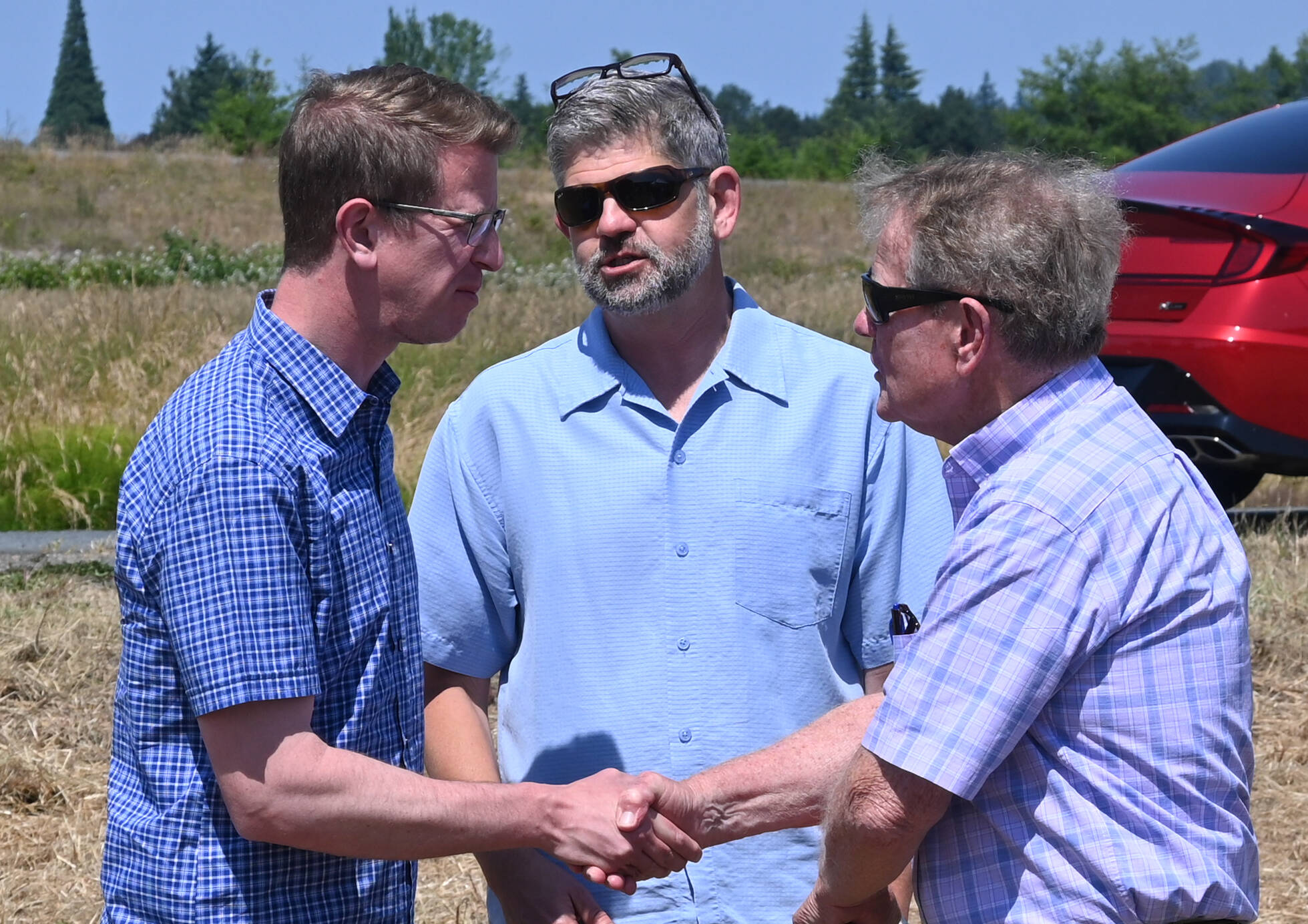 U.S. Rep. Derek Kilmer, left, talks with Clallam County commissioners Mark Ozias and Randy Johnson at a groundbreaking of the Brownfield Road Project in Sequim. (Michael Dashiell/Olympic Peninsula News Group)