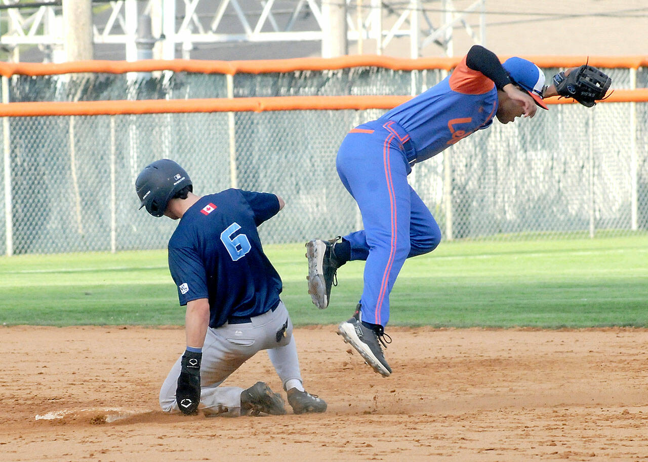 KEITH THORPE/PENINSULA DAILY NEWS Lefties second baseman Roberto Nuñez III is pushed off-balance into the air by charging Edmondton baserunner Brett Ott after Ott was forced out at second during the fourth inning on Wednesday at Port Angeles Civic Field.