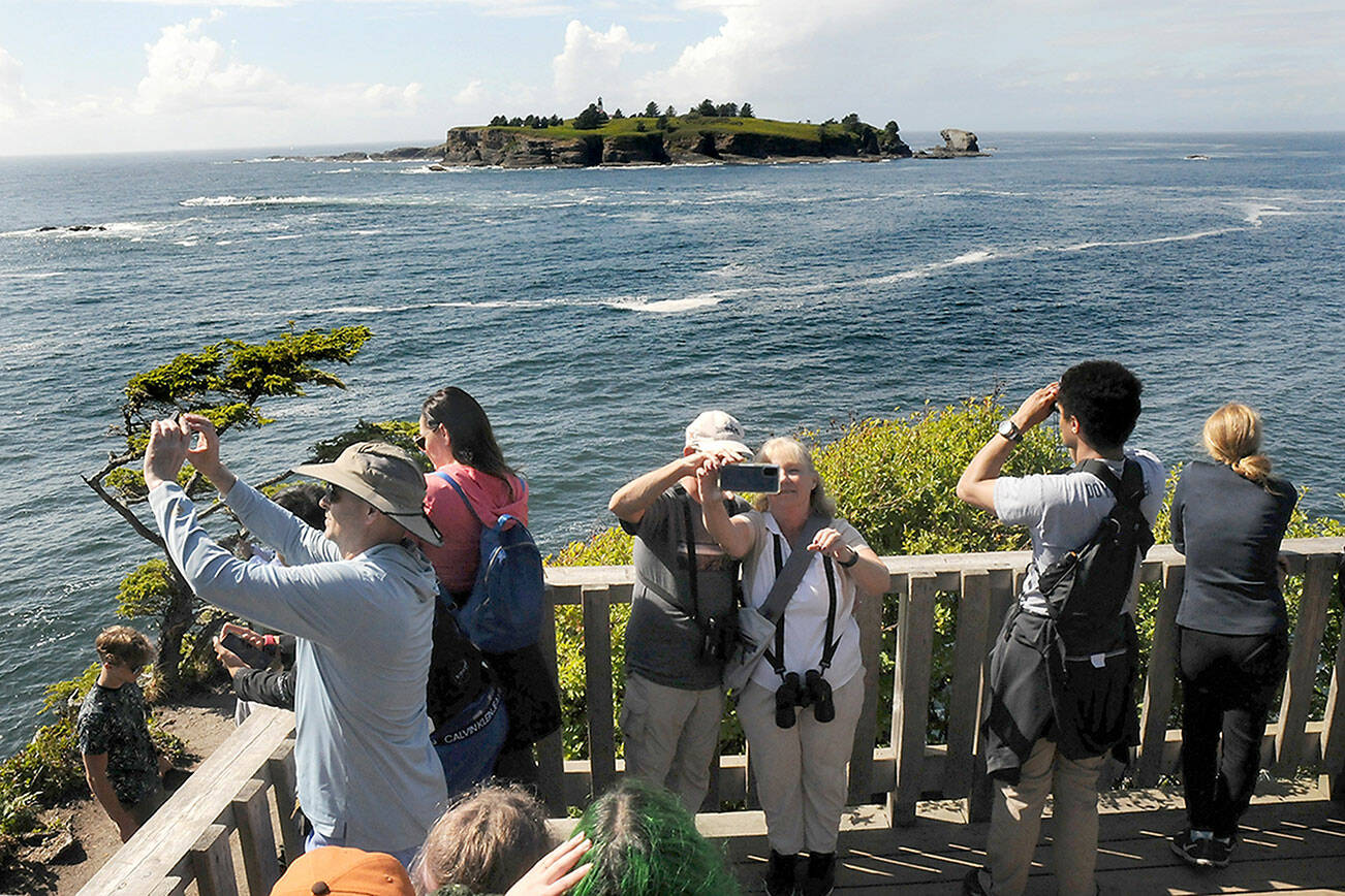 Visitors to Cape Flattery, the northwesternmost point in the contiguous United States, take scenic photos and selfies from the viewing platform on Tuesday as Tatoosh Island lies in the distance. The popular tourist attraction is part of an area administered by the Makah Tribe in Neah Bay. (Keith Thorpe/Peninsula Daily News)