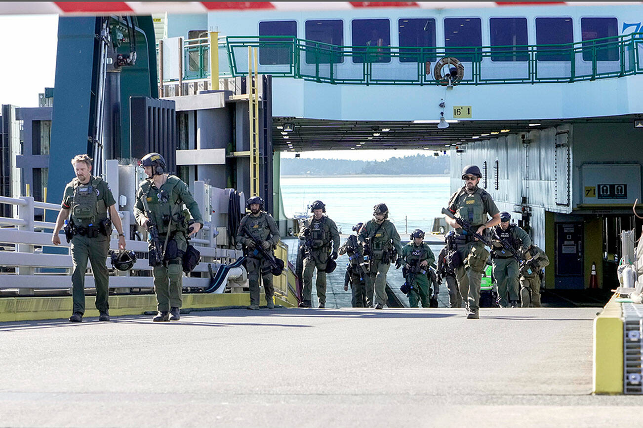 A multi-agency police force walks up the ramp after conducting a high-risk, low-frequency training exercise on board the M/V Kennewick on Wednesday. High risk refers to the level of danger to people and property, i.e., a hostage situation, and low frequency refers to the chance of it actually happening, but the agencies want to be prepared by training. The force was made up with personnel from the Port Townsend, Port Angeles and Sequim police departments and both the Clallam and Jefferson county sheriff’s departments as well as from customs enforcement. The 8 a.m. and 9:30 a.m. ferries from Port Townsend were cancelled due to low tides, so travel was not impacted during the exercise. (Steve Mullensky/for Peninsula Daily News)
