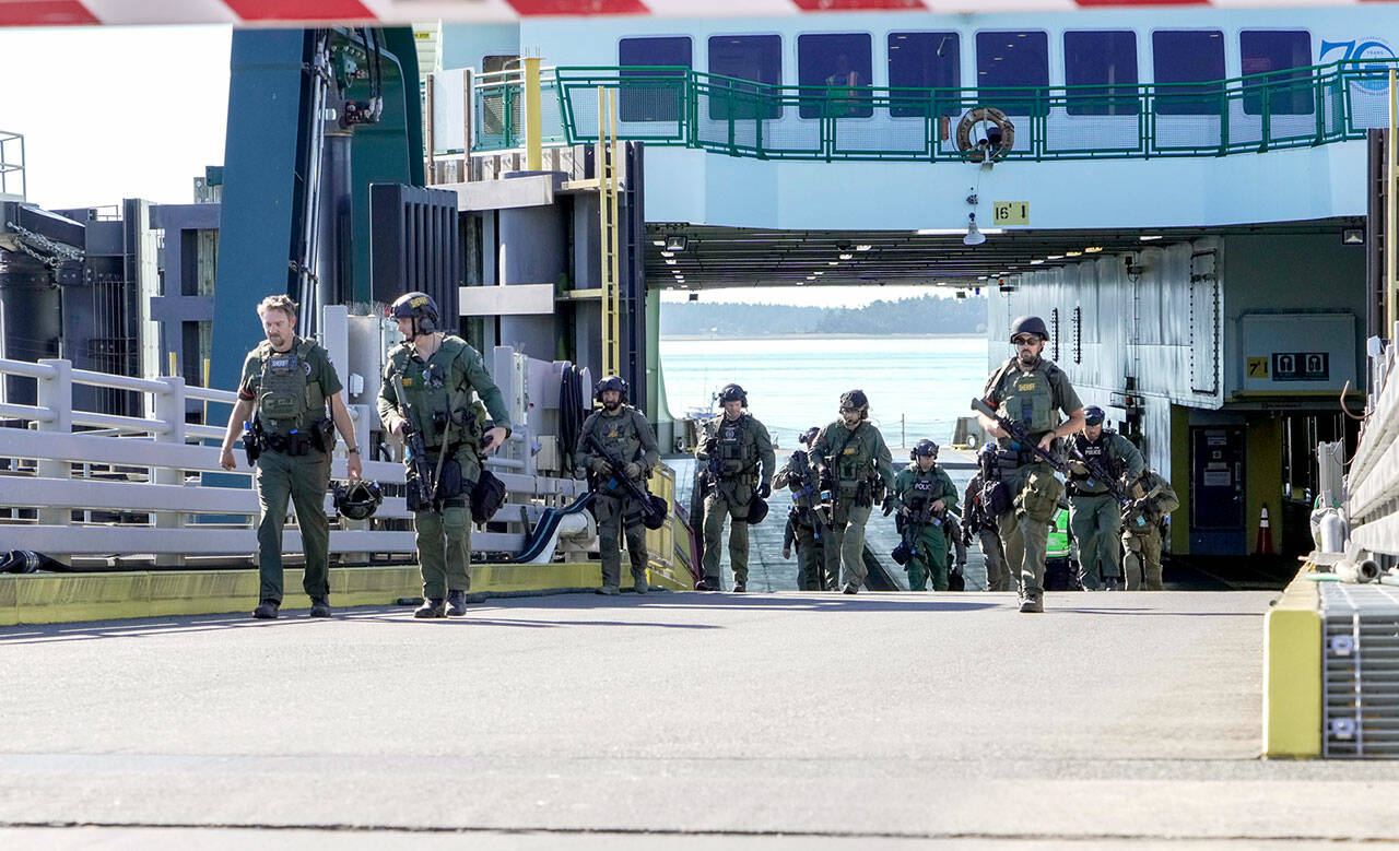 A multi-agency police force walks up the ramp after conducting a high-risk, low-frequency training exercise on board the M/V Kennewick on Wednesday. High risk refers to the level of danger to people and property, i.e., a hostage situation, and low frequency refers to the chance of it actually happening, but the agencies want to be prepared by training. The force was made up with personnel from the Port Townsend, Port Angeles and Sequim police departments and both the Clallam and Jefferson county sheriff’s departments as well as from customs enforcement. The 8 a.m. and 9:30 a.m. ferries from Port Townsend were cancelled due to low tides, so travel was not impacted during the exercise. (Steve Mullensky/for Peninsula Daily News)