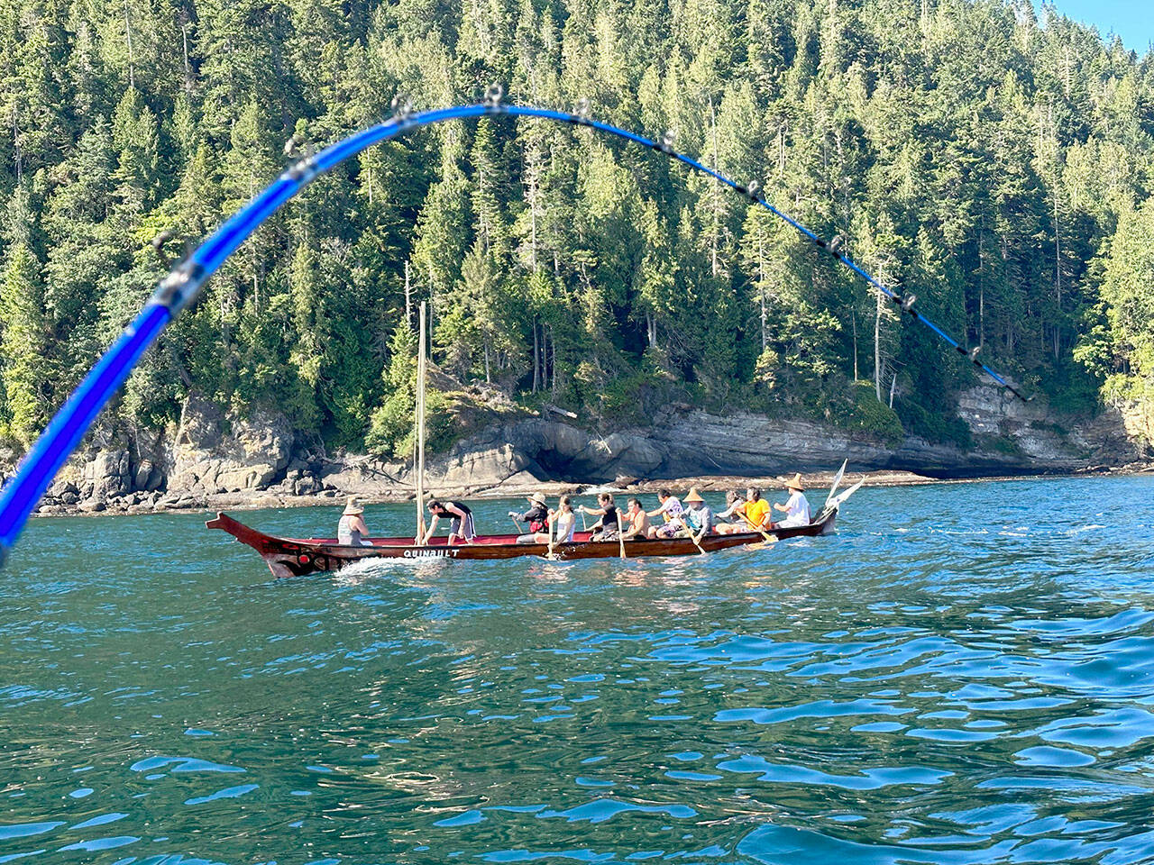 The Quinault Nation canoe cuts through Freshwater Bay on the way to the mouth of the Elwha River and passes the downrigger line of Sequim angler John L. Beath during a July 23 fishing outing. (John L. Beath)