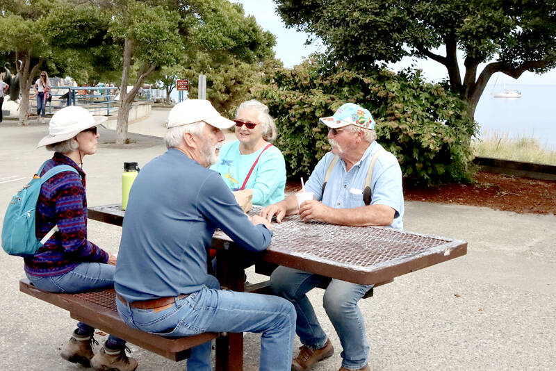 Carol and Greg Shinsky of Port Angeles take an afternoon break on a picnic table at the Port Angeles City Pier with visiting friends. Gay and Russ James, right, are visiting from Orland, Calif., where the temperature has been over 100 degrees. They rested at the pier after visiting Hurricane Ridge and the Dungeness Spit. The couples have known each other for years from when they both lived in Arizona. (Dave Logan/for Peninsula Daily News)