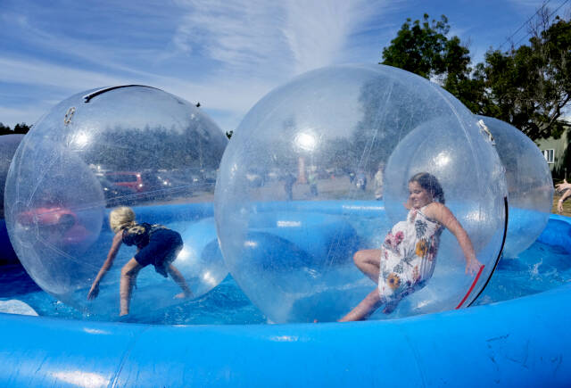 Emma Miller, 11, right, and best friend Lorelei Sanders, 11, both from Sequim, bounce around in the floating bubbles while at the 2023 Jefferson County Fair on Friday. (Steve Mullensky/for Peninsula Daily News)
