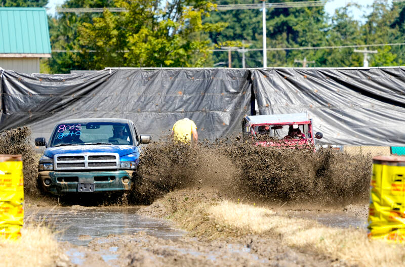 Richard Bauden of Port Angeles, left, in a 2000 Dodge, gets edged out for second place by Poulsbo’s Carl Jantz, driving a 1942 Willys Jeep during the Jefferson County Fair in Port Townsend on Sunday. Jantz won the 2014 Alaska Offroad Warriors reality competition off-road race with this vehicle, which covered 1,100 miles from south to north to the Arctic Ocean. (Steve Mullensky/for Peninsula Daily News)