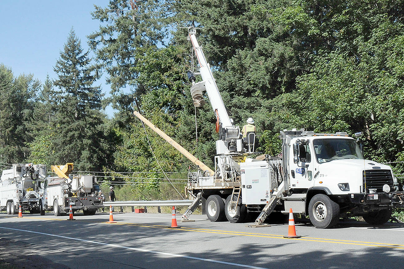 KEITH THORPE/PENINSULA DAILY NEWS
Clallam County Public Utility District crews erect a broken power pole along U.S. Highway 101 at Wildcat Road west of Port Angeles on Wednesday.