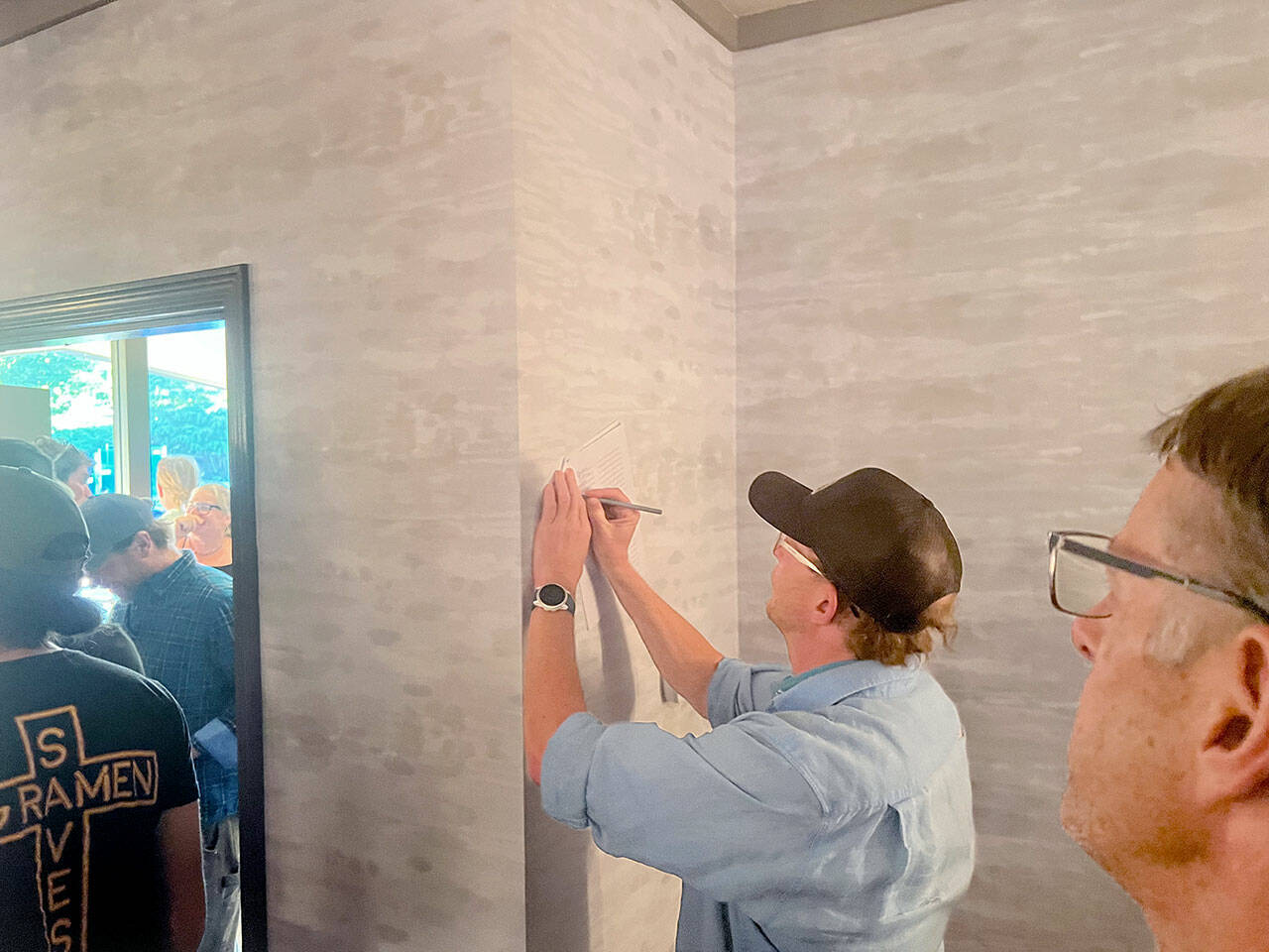 Eric Coufal signs a letter urging Olympic National Park officials to ensure access to Hurricane Ridge this winter. Locals have been concerned about winter access after the ridges day lodge burned down in May. A local coalition held a meeting at the Red Lion Hotel in Port Angeles on Wednesday to discuss the situation. (Peter Segall/Peninsula Daily News)