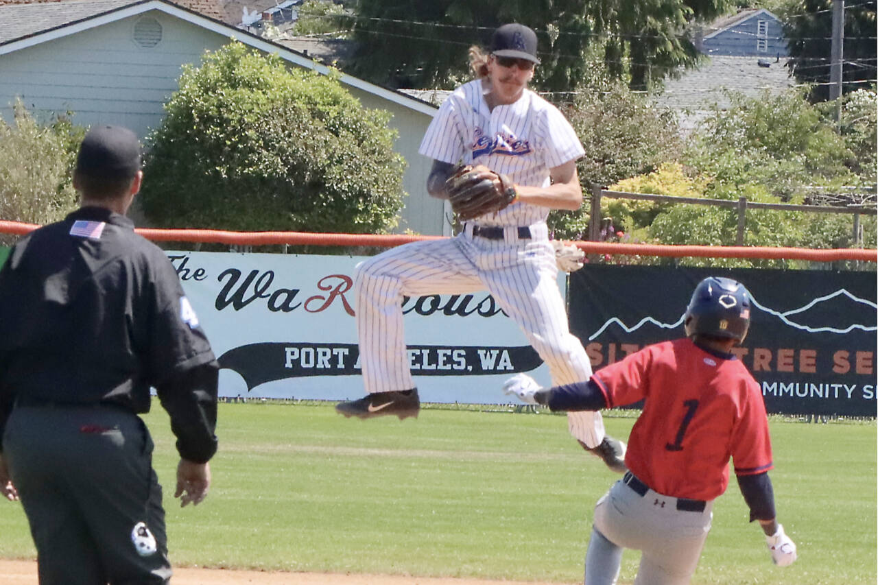 Port Angeles Lefties second baseman Robert Nunez jumps to catch a throw but isn't able to punch out Kelowna baserunner Eddie Fines on Sunday at Civic Field. (Dave Logan/for Peninsula Daily News)