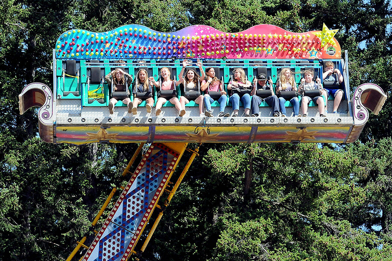 KEITH THORPE/PENINSULA DAILY NEWS
Carnival-goers take a spin through the air on the Ali Baba amusement ride at the Clallam County Fair in Port Angeles on Friday.