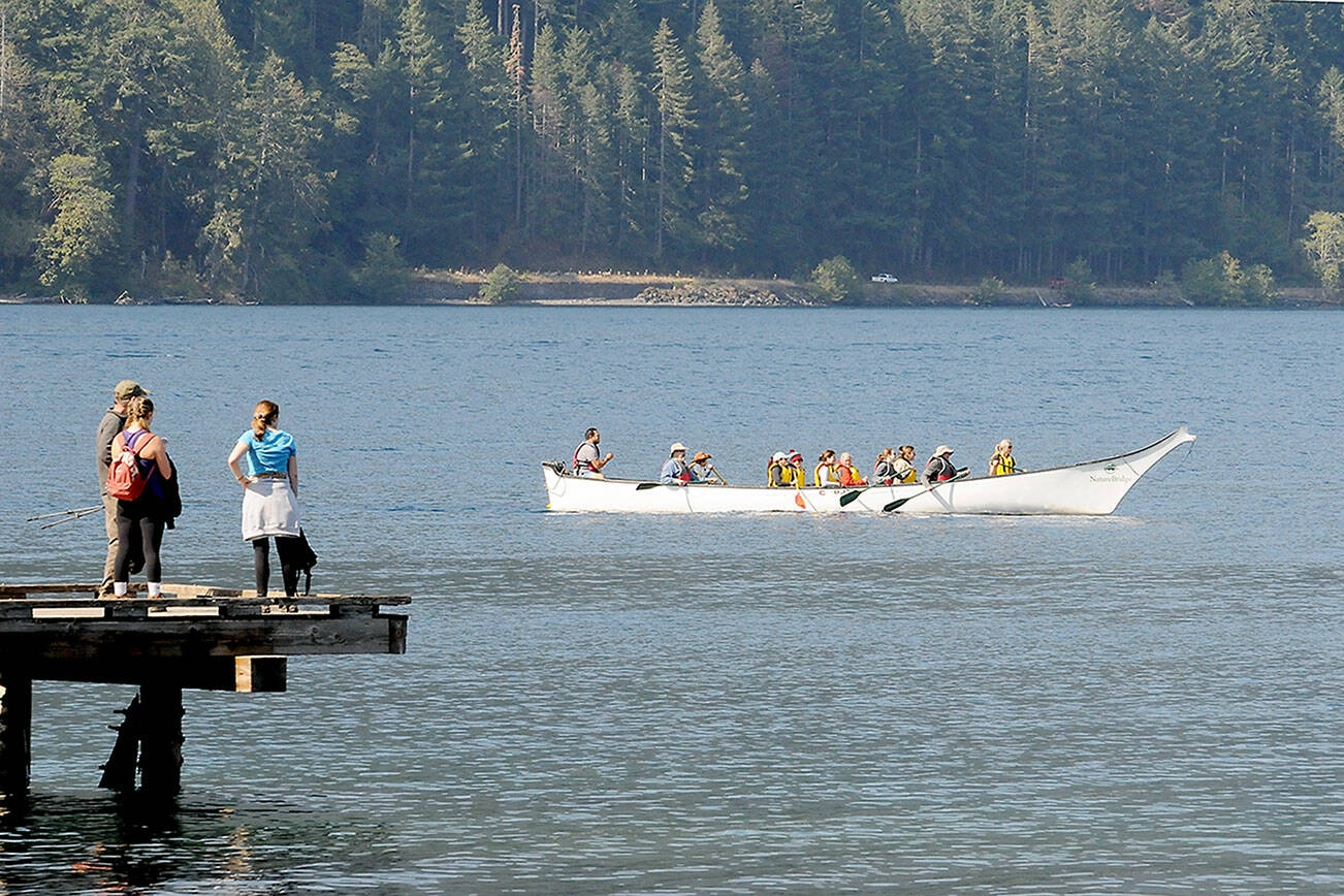 A canoe containing visitors to Nature Bridge at Lake Crescent in Olympic National Park makes its way past the dock at Lake Crescent Lodge on Thursday. The canoe was one of a pair plying the waters of the lake, mixing with a variety of other paddleboards and kayaks in the Barnes Point area. (Keith Thorpe/Peninsula Daily News)