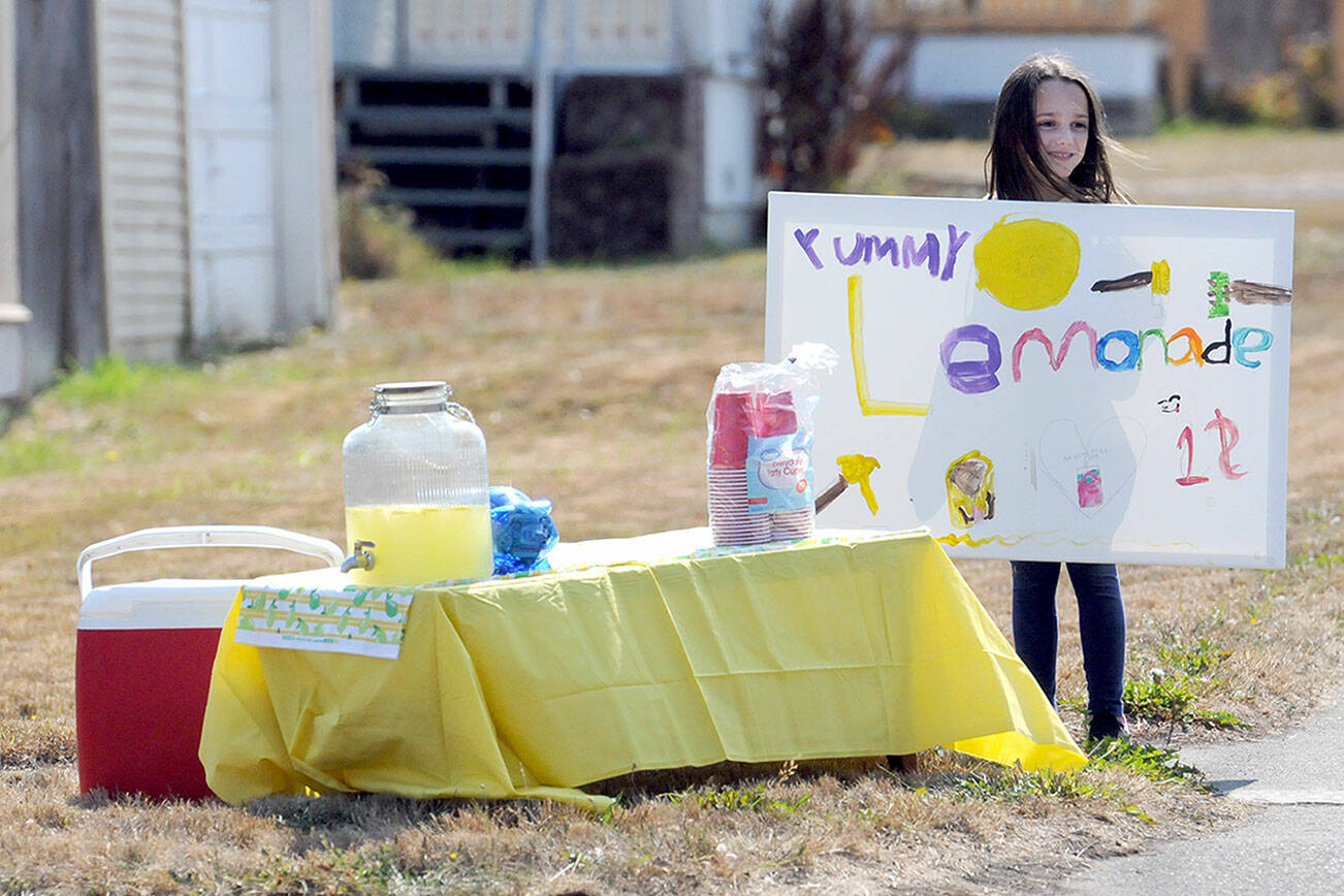 Addison Bell, 9, tries to drum up business for her lemonade stand at Fourth and Race streets in Port Angeles. The youngster said she had taken in about $70 before running out of product. She said a portion of the proceeds were slated to go to the Olympic Peninsula Humane Society with some set aside for herself. (Keith Thorpe/Peninsula Daily News)