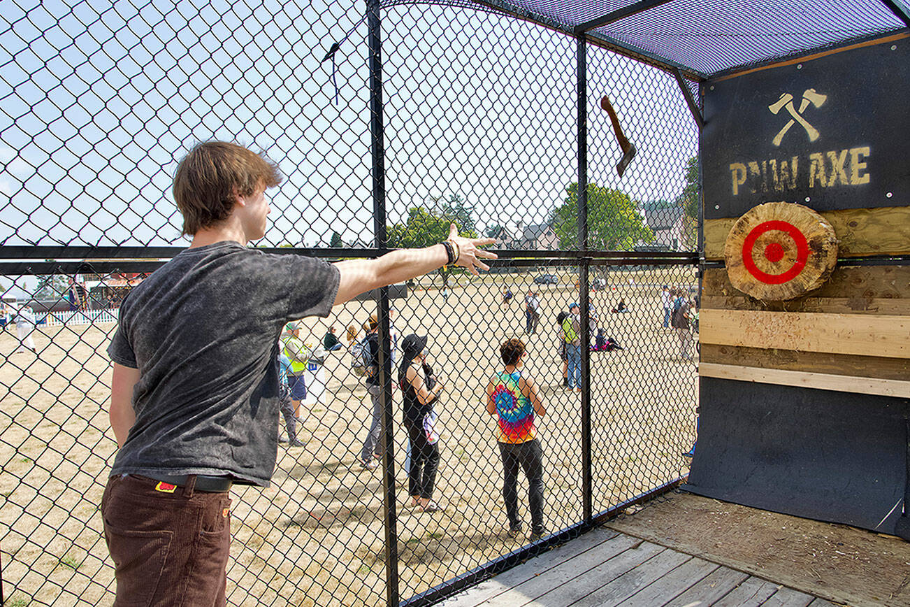 Steve Mullensky/for Peninsula Daily News 

Dayton Brown, from Sammamish, aims for the bull’s eye in the PNWAXE cage during THING music and arts festival on the Parade grounds of Fort Worden State Park on Friday. THING continues today and Sunday.
