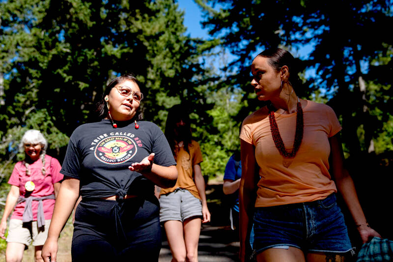 Serina Fast Horse, of Sicangu Lakota & Blackfeet Tribes, left, talks with Jacy Bowles, of Xicana and Diné descent, as they walk to the former Elwha Dam site during the 2023 Tribal Climate Camp on the Olympic Peninsula on Aug. 16 near Port Angeles. Participants representing at least 28 tribes and intertribal organizations gathered to connect and share knowledge as they work to adapt to climate change that disproportionally affects Indigenous communities. More than 70 tribes have taken part in the camps that have been held across the United States since 2016. (Lindsey Wasson/The Associated Press)