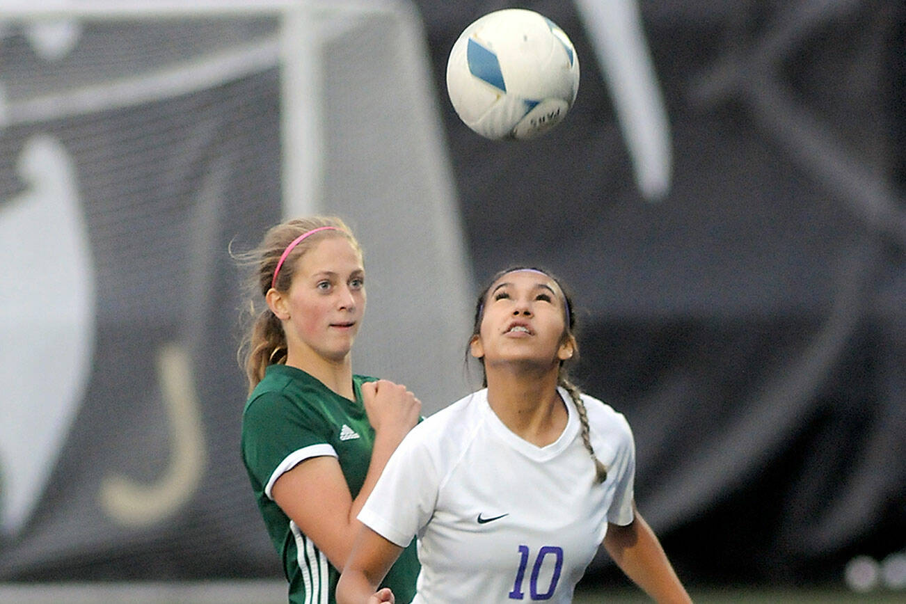 Sequim’s Jennyfer Gomez, front, takes a header in front of Port Angeles’ Becca Manson last year at Wally Sigmar Field in Port Angeles. Gomez, a second-team all-Olympic League selection, is back this year as a strong midfielder for the Wolves. (Keith Thorpe/Peninsula Daily News)
