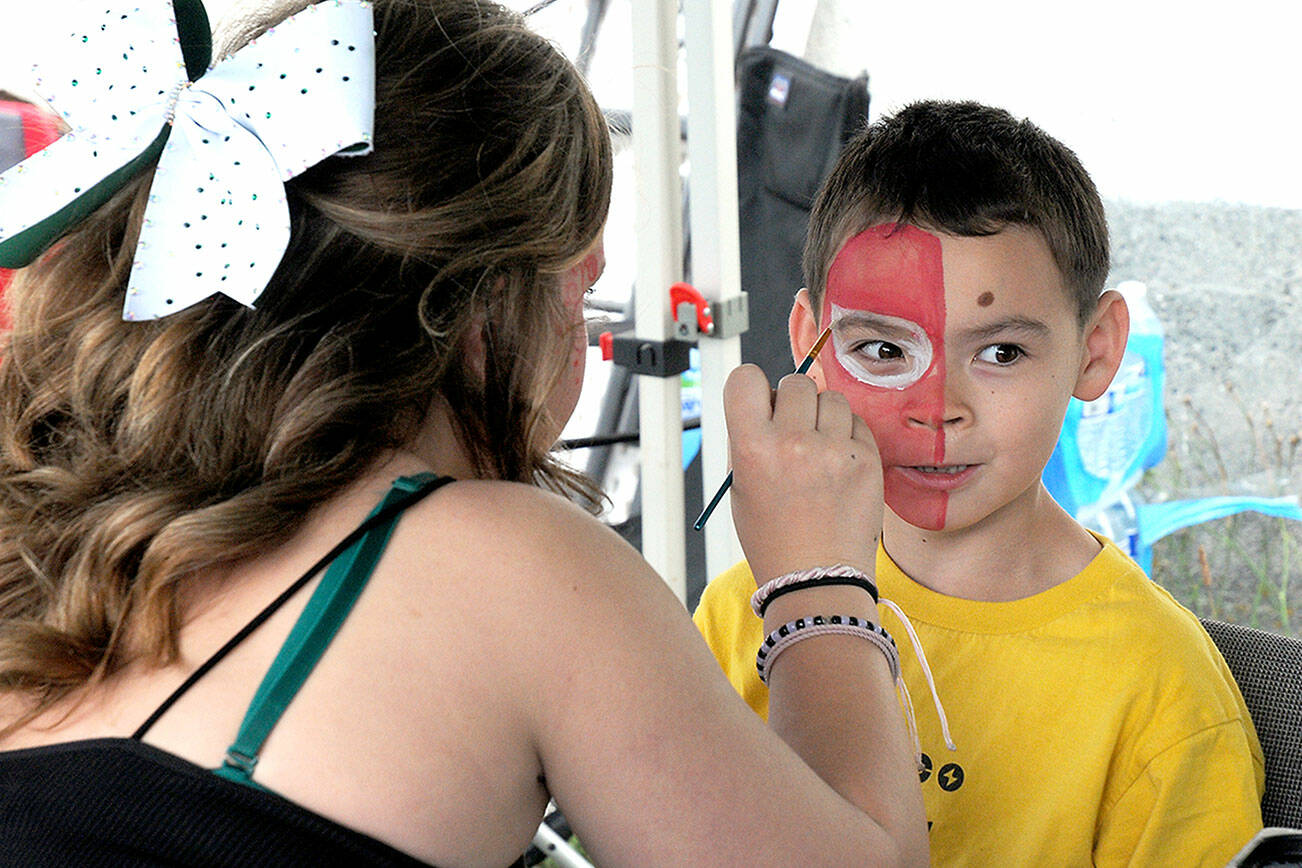 Alden Inman, 7, of Port Angeles gets his face painted by Ailey Thibeault during Sunday’s First Federal centennial celebration and community party in downtown Port Angeles. The event featured a day of food, music and children’s activities in honor of the organization’s 100 years as a community bank. (Keith Thorpe/Peninsula Daily News)