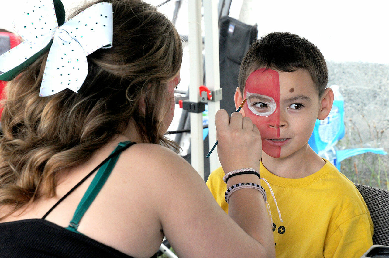 Alden Inman, 7, of Port Angeles gets his face painted by Ailey Thibeault during Sunday’s First Federal centennial celebration and community party in downtown Port Angeles. The event featured a day of food, music and children’s activities in honor of the organization’s 100 years as a community bank. (Keith Thorpe/Peninsula Daily News)
