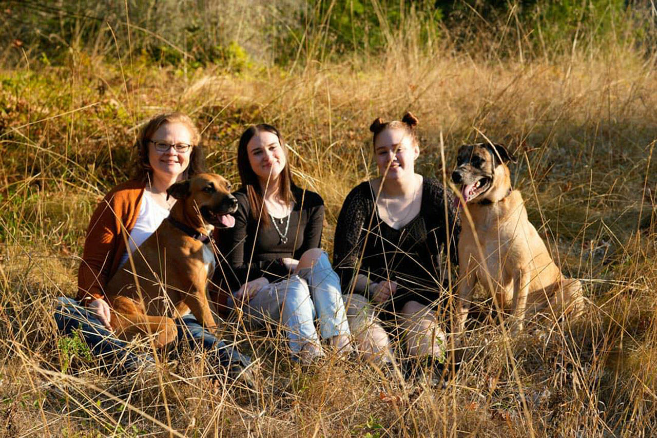 Rachael Healey, left, and her two daughters, Kaitlyn, 18, middle, and Kenzie, 16, right, lost their Dungeness home and two dogs Stella, front left, and Ollie, in a fire on Aug. 23. The family seeks a new place to rent as they live in a hotel while continuing to work and go to school. (Rachael Healey)