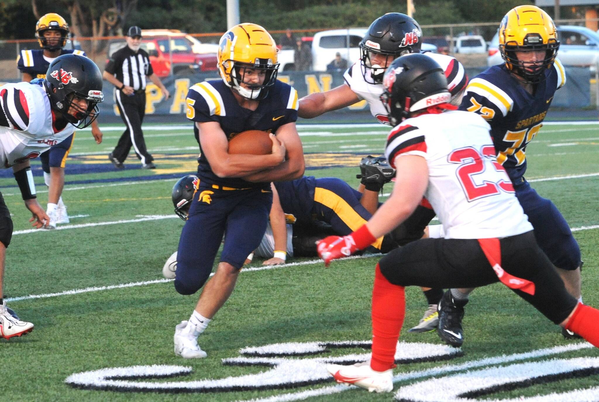 Forks' Landin Davis (5) runs through a host of Red Devils as he faces Neah Bay's JQ Johnson (23). Also in the action is Forks' Jeremy Hutto (72). (Lonnie Archibald/for Peninsula Daily News)