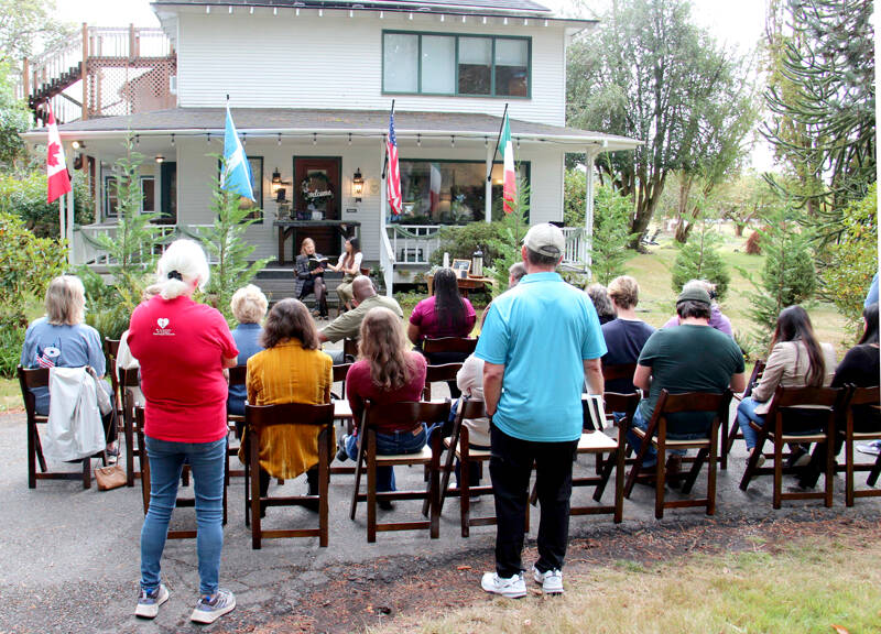 Author M.B. Thurman reads from her debut novel, “Summoned,” in front of the Miller Tree Inn, aka the Cullen House, during a pre-Forever Twilight in Forks event on Tuesday. M.B. (Mary Beth) and her husband Trent own the Inn. This week’s FTF Festival will also feature other authors at several other venues. (Christi Baron/Olympic Peninsula News Group)