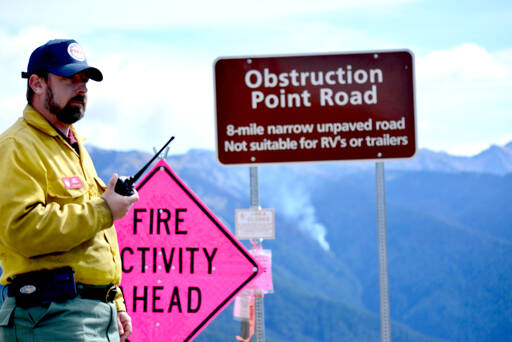Mike Theune, regional fire communication and education specialist with the National Park Service, listens to the radio at Hurricane Ridge on Wednesday as fire crews prepare for a helicopter to help move equipment out of the park. Several wildfires have been burning in Olympic National Park and firefighters are mostly letting the fires run their course. (Peter Segall/Peninsula Daily News)