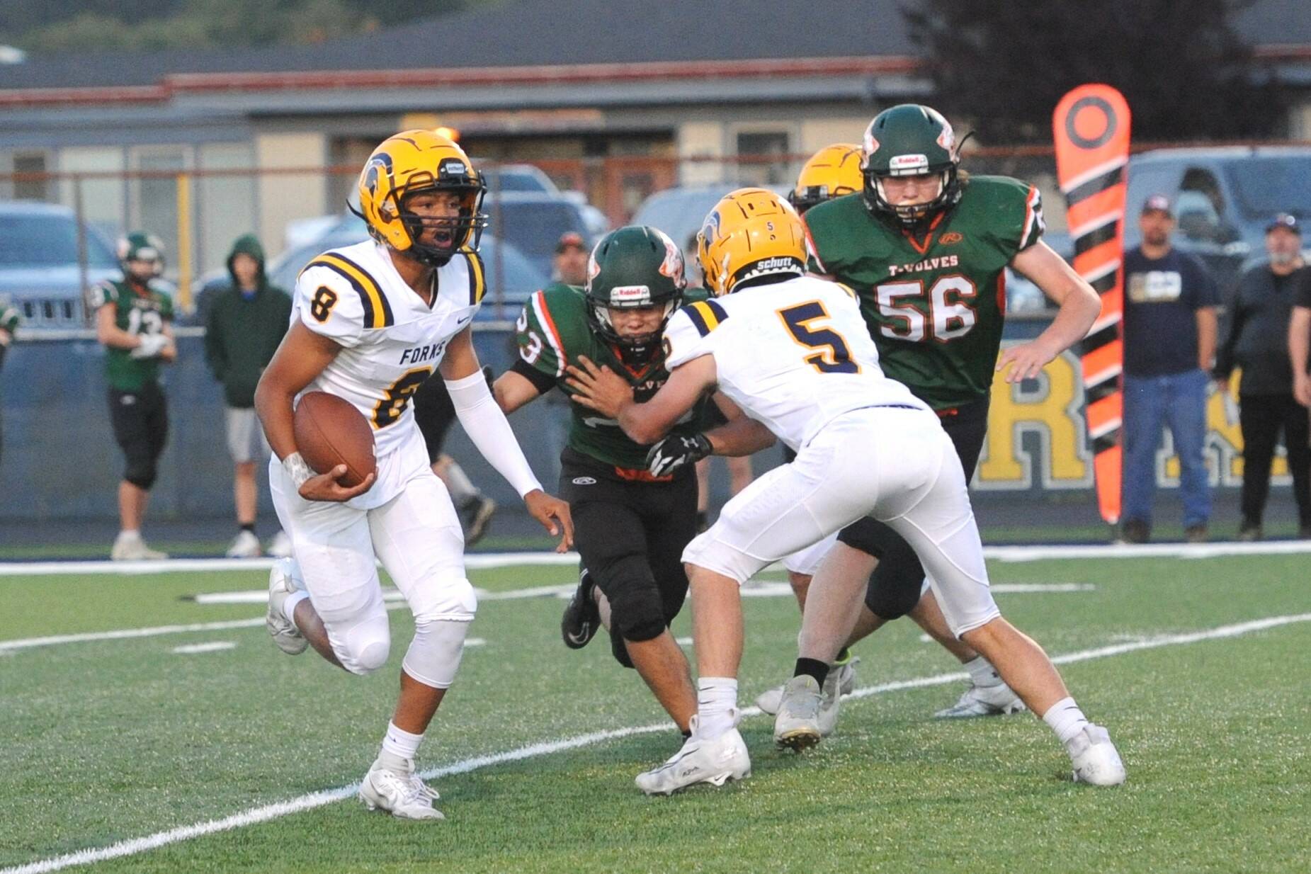 Forks quarterback Bubba Hernandez (8) runs the ball against Morton-White Pass on Friday night as Landin Davis (5) blocks. Hernandez had three touchdown passes and a 56-yard touchdown run as Forks won 40-0. (Lonnie Archibald/for Peninsula Daily News)