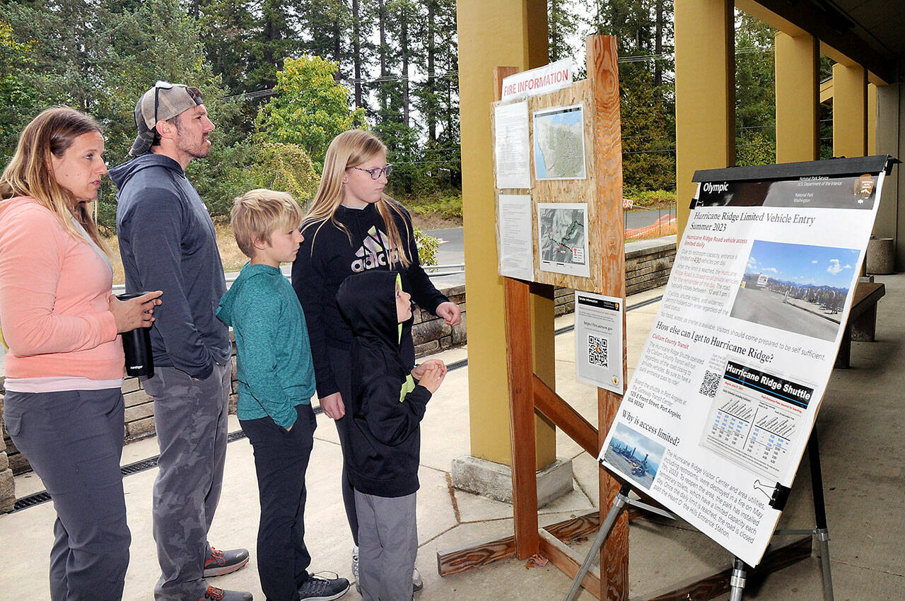 Members of the Bagley family of Forsyth, Ill., from left, parents Jessica and Cameron Bagley, and children Cody, 10, Addie, 12, and C.J., 7, look at an information kiosk on the Olympic National Park wildfires on Tuesday in front of the park visitor center in Port Angeles. (Keith Thorpe/Peninsula Daily News)