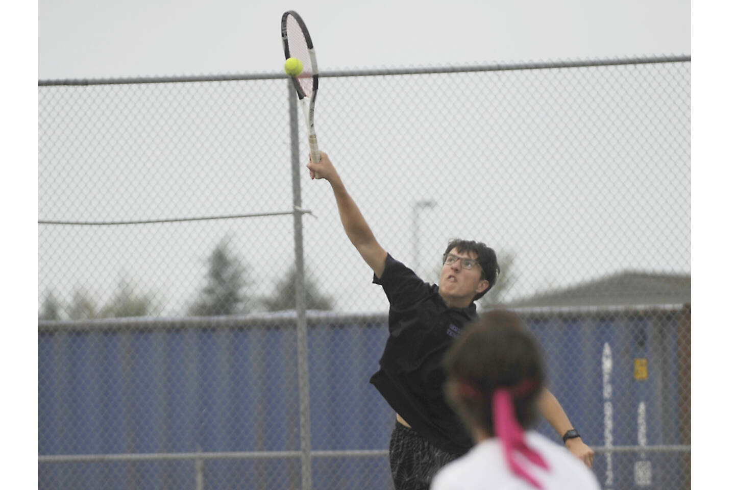 Sequim’s William Hughes returns a shot in tennis action in Sequim against Olympic on Tuesday. (Michael Dashiell/Olympic Peninsula News Group)