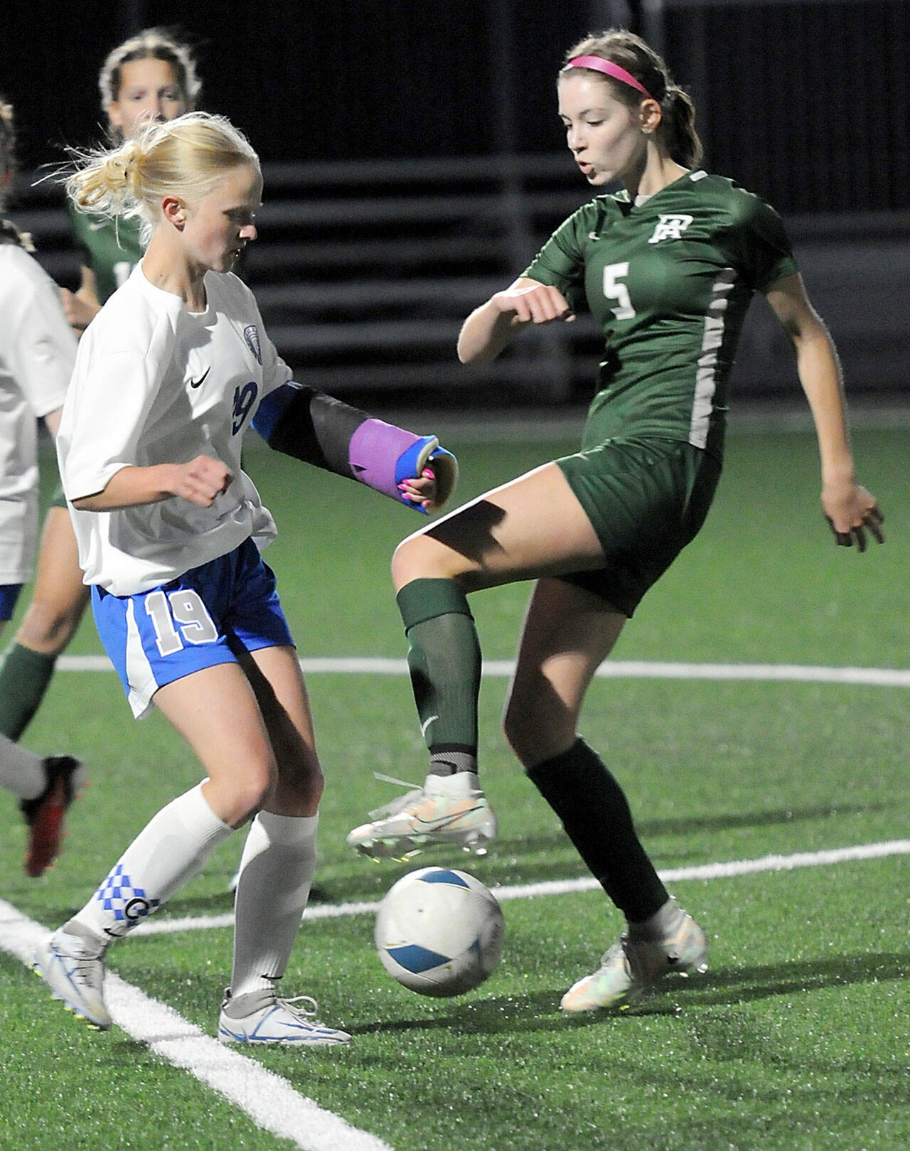 KEITH THORPE/PENINSULA DAILY NEWS Port Angeles’ Keds DeScala, right, fends off the defense of Olympic’s Emma Sagee during Thursday’s match at Wally Sigmar Field in Port Angeles.