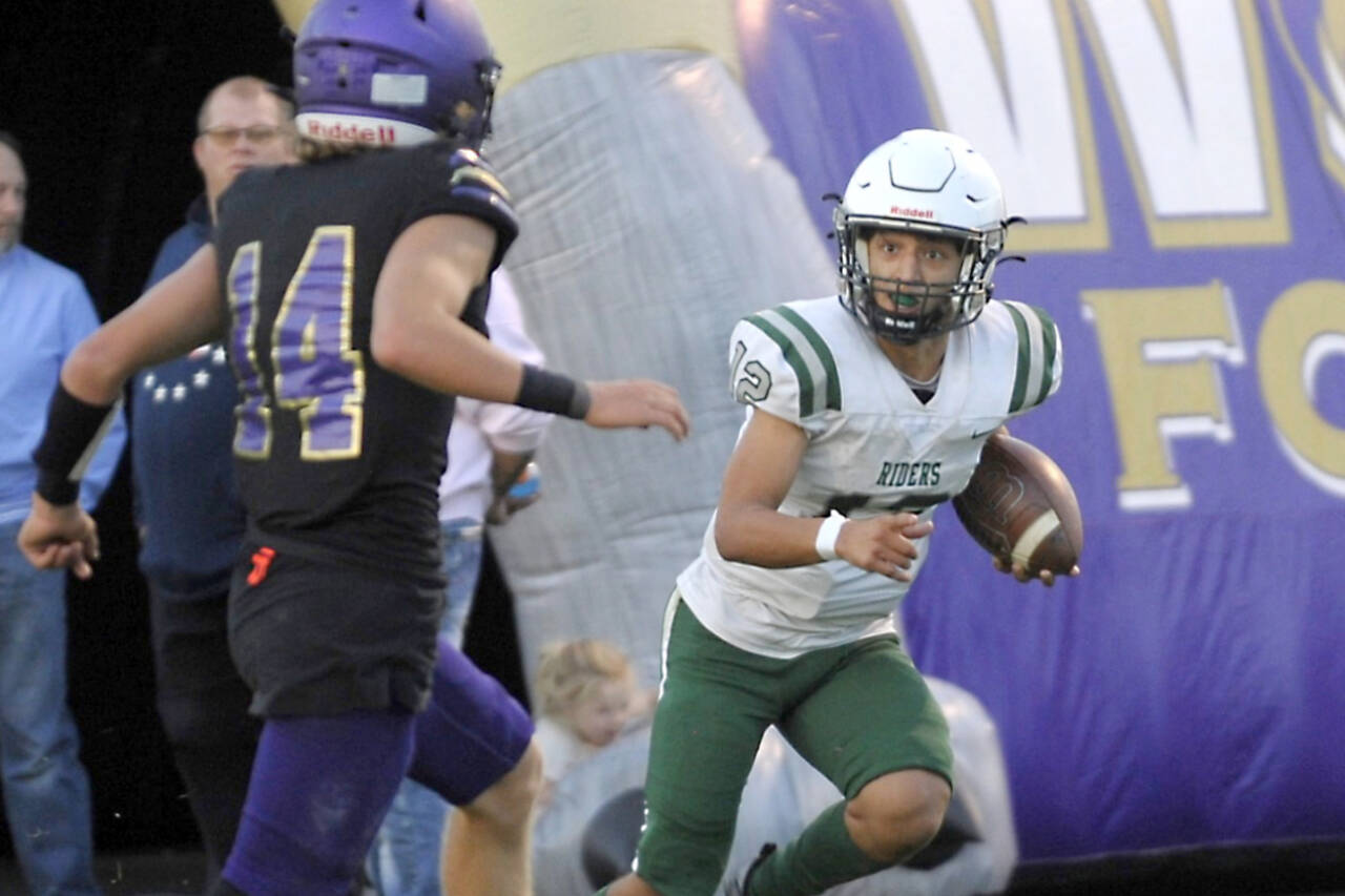 Port Angeles' Kason Albaugh (12) runs against Sequim's Zeke Schmadeke (14) in the Rainshadow Rumble game in Sequim on Friday night. The Roughriders scored 27 points in the fourth quarter to win 37-10. (Michael Dashiell/Olympic Peninsula News Group)