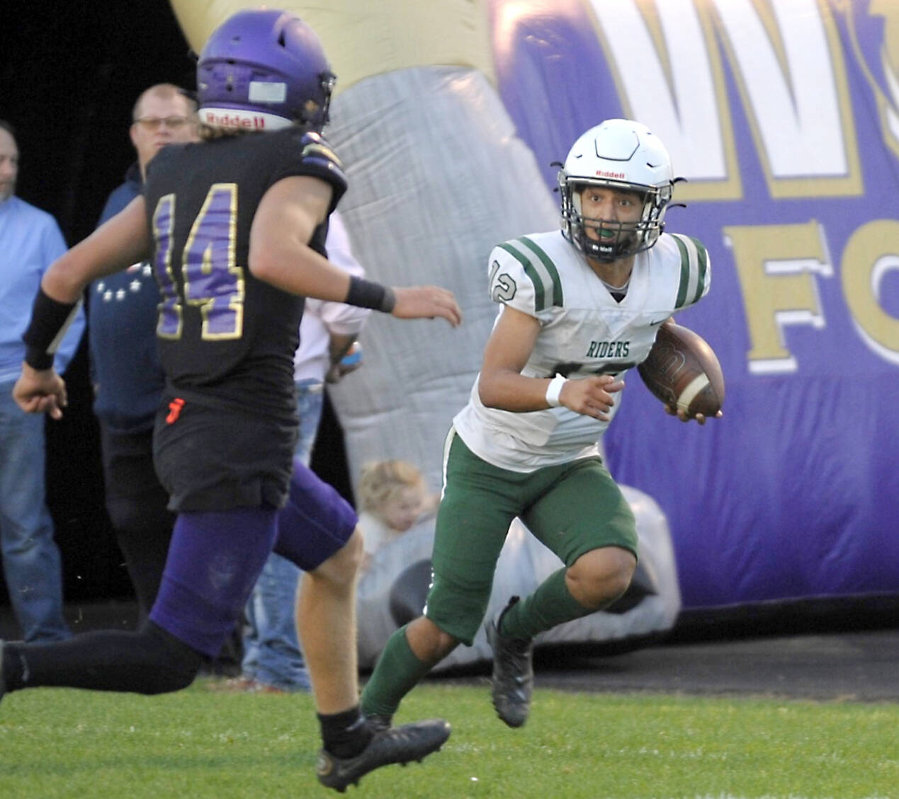 Port Angeles’ Kason Albaugh (12) runs against Sequim’s Zeke Schmadeke (14) in the Rainshadow Rumble game in Sequim on Friday night. The Roughriders scored 27 points in the fourth quarter to win 37-10. (Michael Dashiell/Olympic Peninsula News Group)
