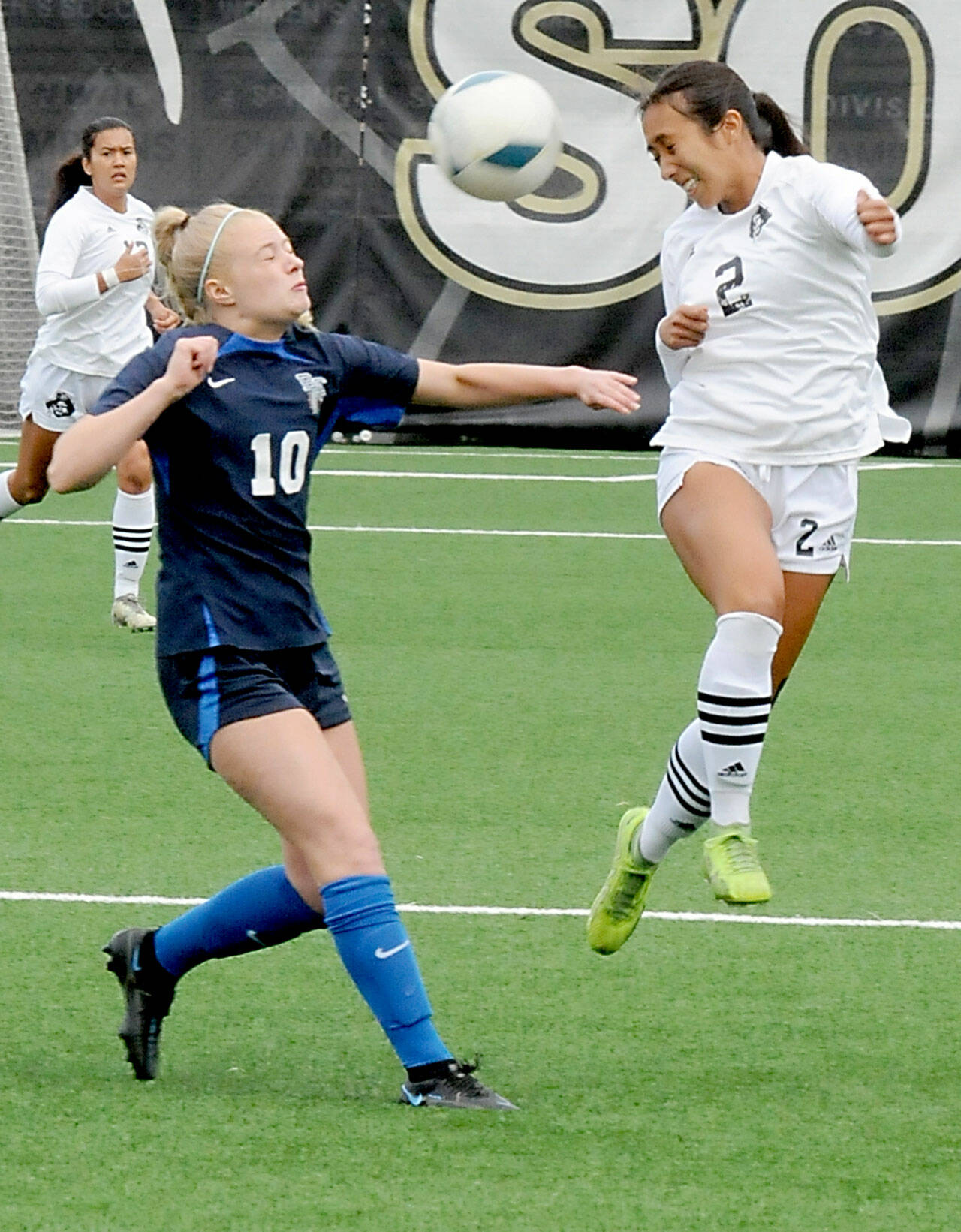 KEITH THORPE/PENINSULA DAILY NEWS Peninsula’s Briana-Jean Tanaka, right, leaps for a header in front of Bellevue’s Giulia Menning on Saturday at Peninsula College in Port Angeles. Looking on from behind is Tanaka’s teammate Keilee Silva.