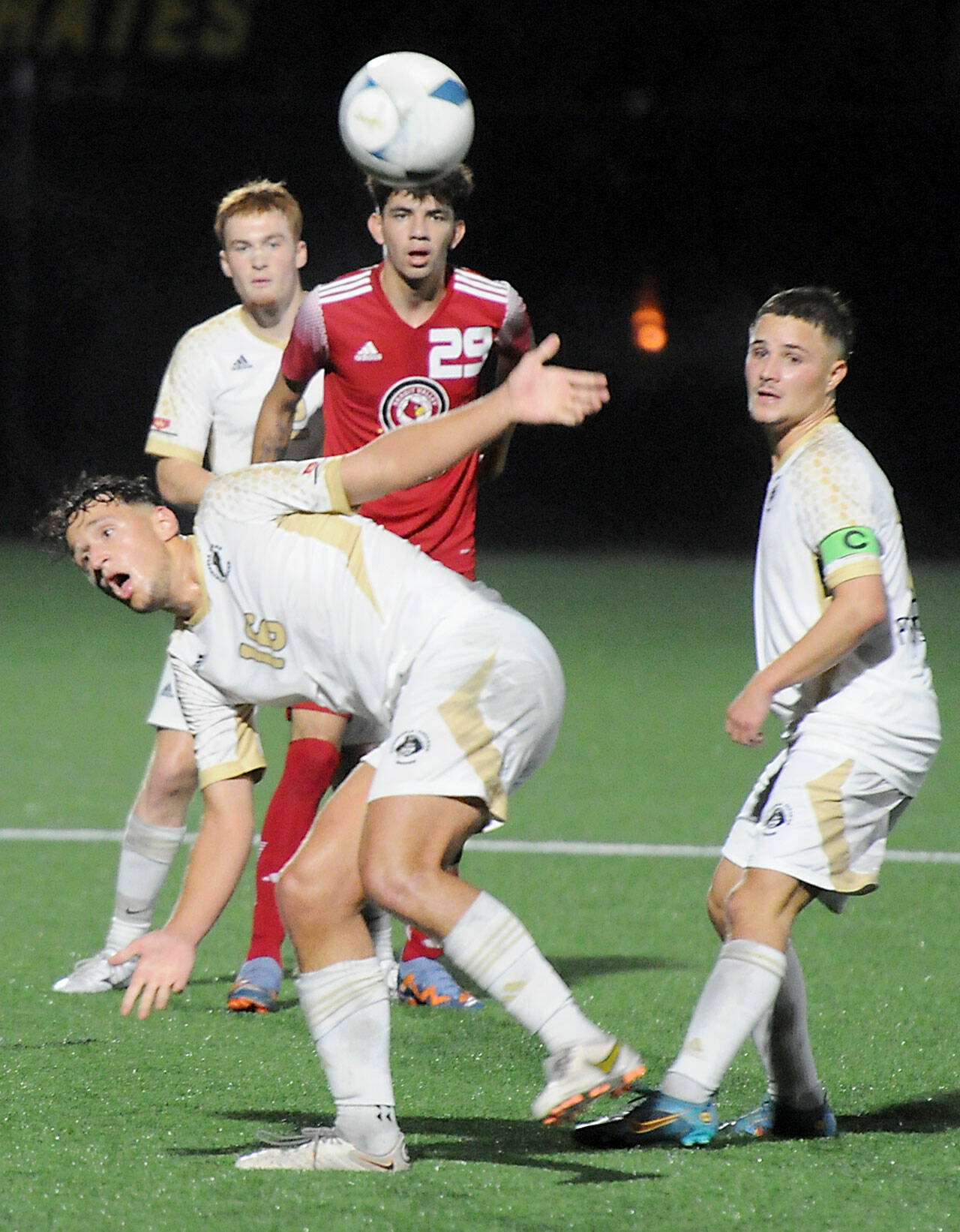 Peninsula’s Konrad Muller, front, lands off balance from a header as teammate Pipvan der Ende, rear left, Skagit Valley’s Iker Trevino and Peninsula’s Maurin Frehner, right, look on during Wednesday’s match at Peninsula College. (Keith Thorpe/Peninsula Daily News)