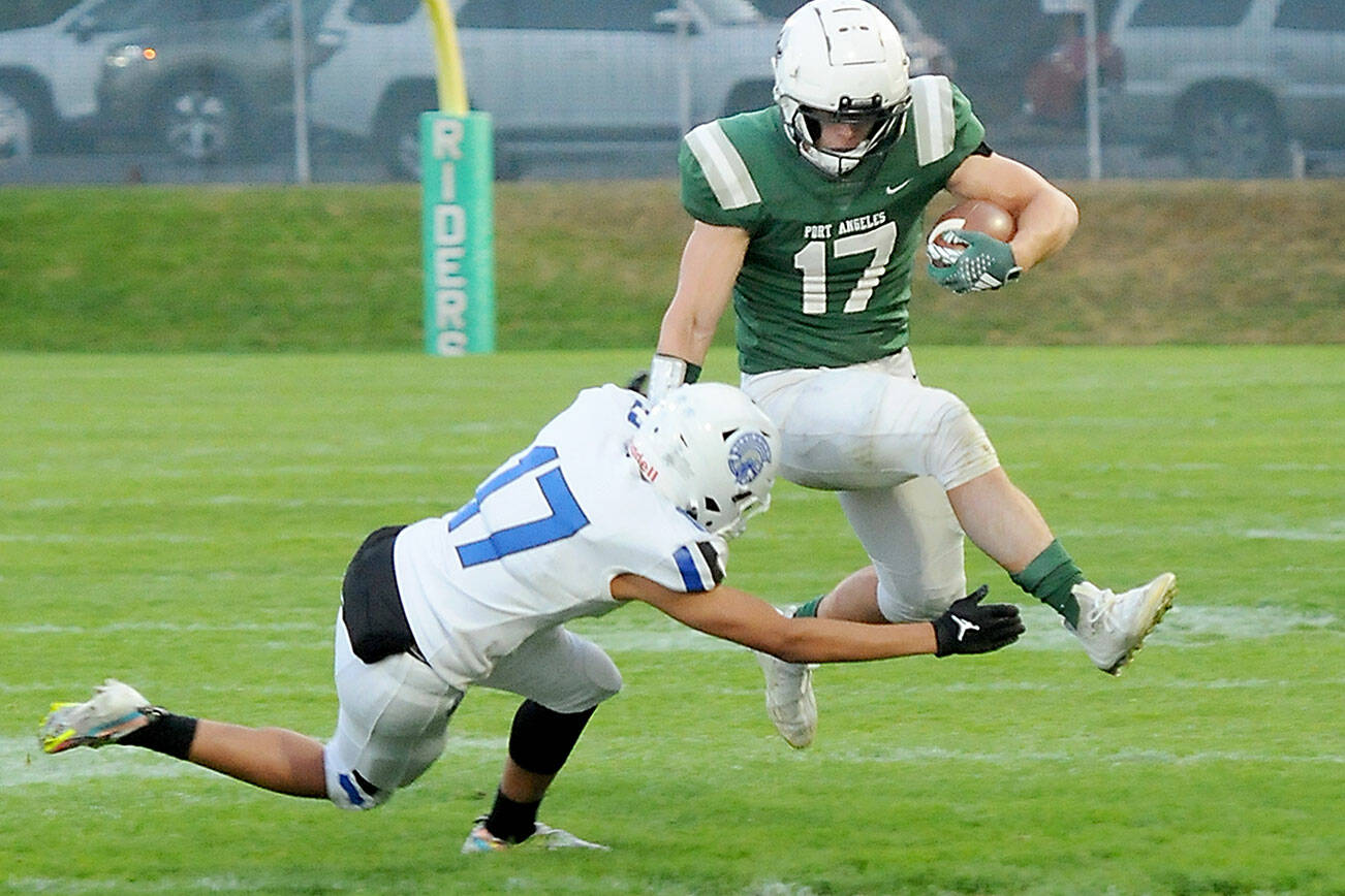 KEITH THORPE/PENINSULA DAILY NEWS
Port Angeles' Jason Hawes, right, tries to evade the tackle of Olympic's Donovan Weaver during Friday's game at Port Angeles Civic Field.