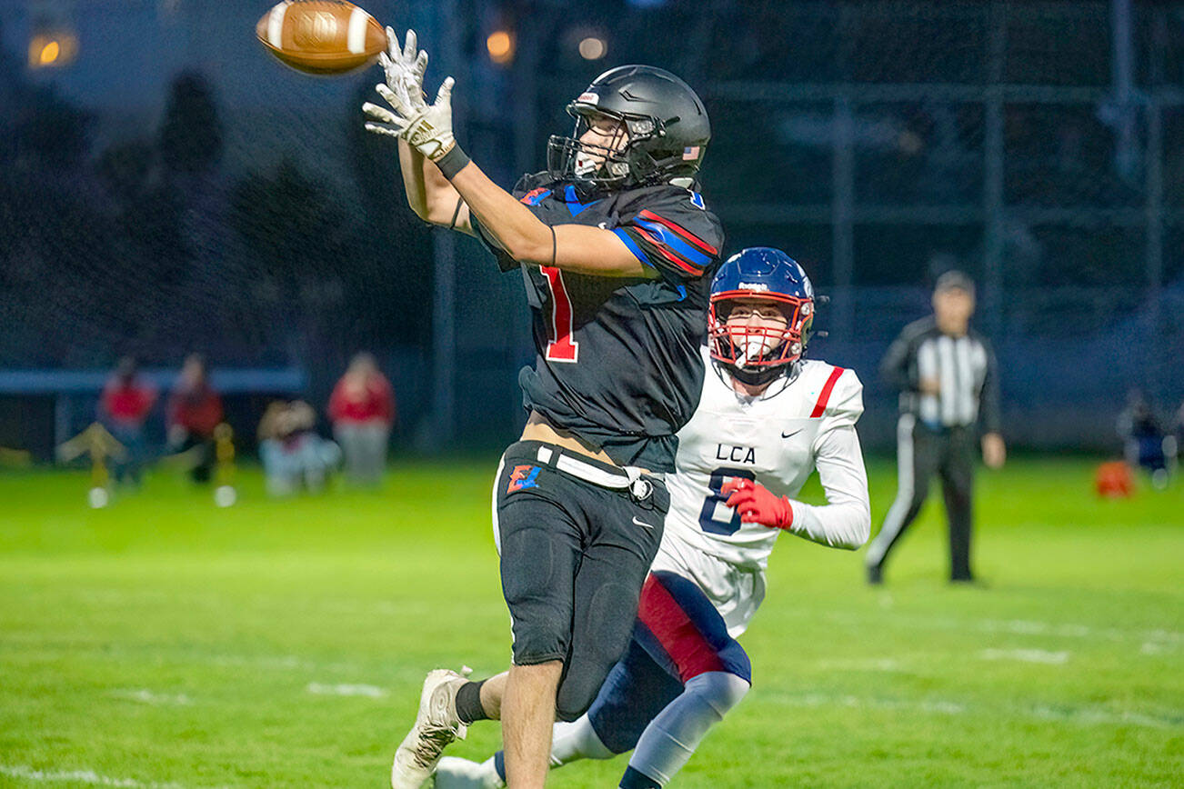 East Jefferson wide receiver Gary Zambor makes the catch for a 15-yard gain and a first down, with Life Christian's Tyler Hamm looking on, in first quarter action Friday night at Port Townsend Memorial Field. Life Christian won 66-12. (Steve Mullensky/for Peninsula Daily News)