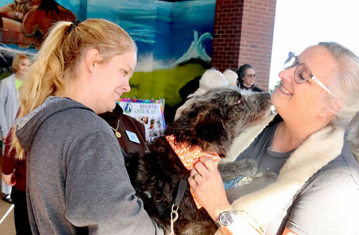 Lily Alexander, left, has her mini Aussiedoodle, Wednesday, blessed by the Rev. Laura Murray of St. Andrews Episcopal Church in Port Angeles. Murray led the Blessing of the Animals on Sunday at the Gateway Transit Center. The annual blessings are performed in celebration of the Feast of St. Francis of Assisi, the 12th century patron saint of animals and the environment. (Dave Logan/for Peninsula Daily News)