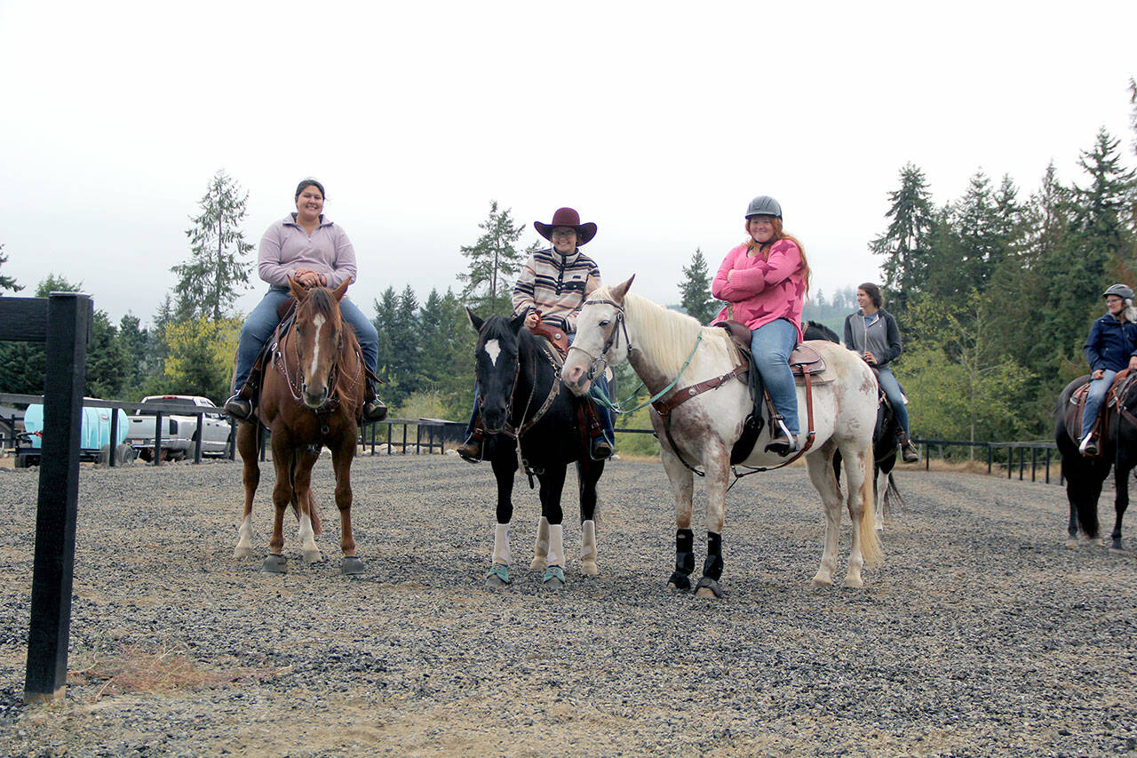 High school friends and equestrian team members Aby Garcia, left, Keri Tucker and Joanna Seelye enjoyed racing through the unusual game patterns and supporting the fundraiser. (Karen Griffiths/for Peninsula Daily News)