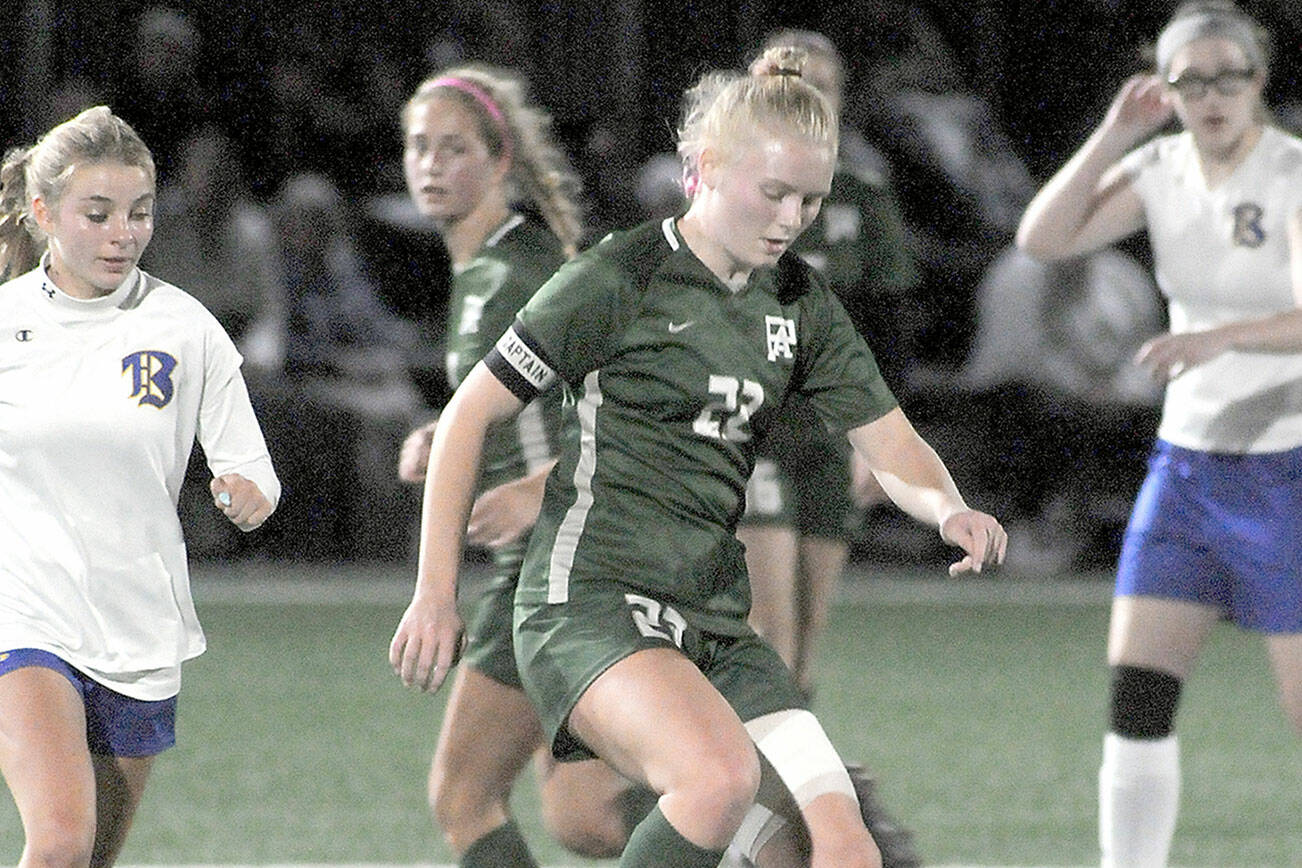 KEITH THORPE/PENINSULA DAILY NEWS
Port Angeles Paige Mason, center, slips past Bremerton's Melanie Unrich at midfieldd during Tuesday's match at Peninsula College.