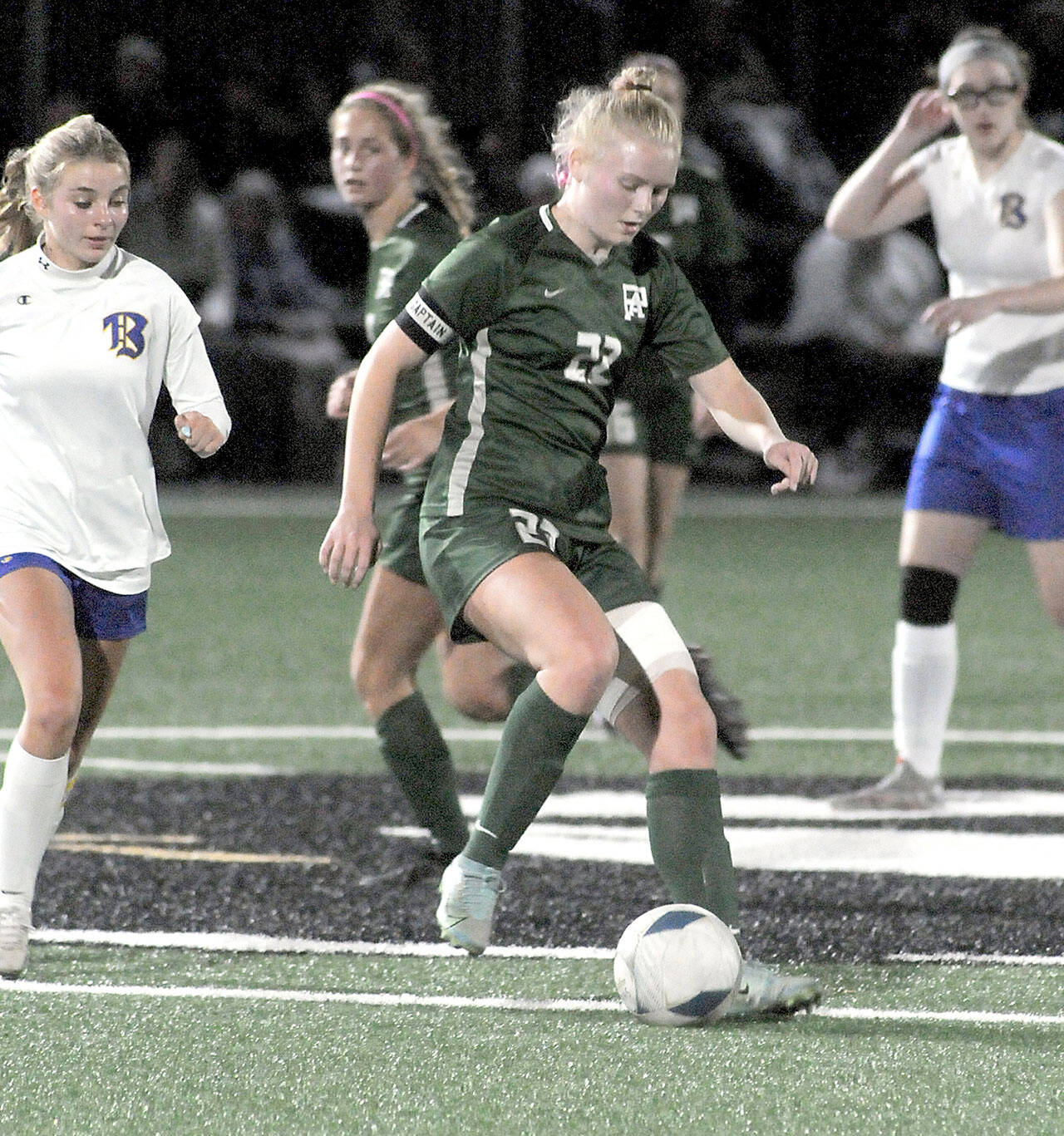 Port Angeles’ Paige Mason, center, slips past Bremerton’s Melanie Unrich at midfieldd during Tuesday’s match at Peninsula College. (Keith Thorpe/Peninsula Daily News)