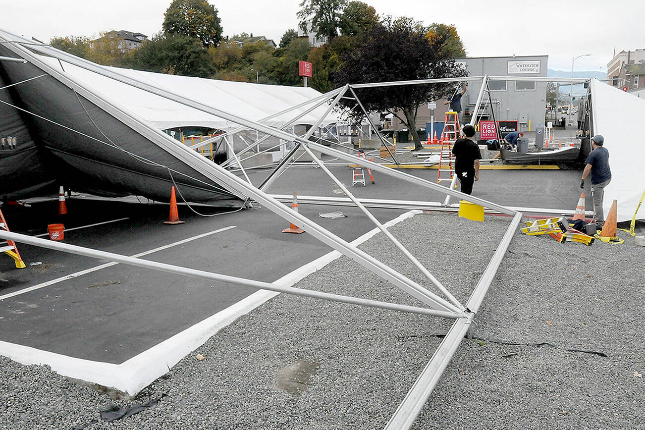 Crews from Bothel-based Grand Event Rentals assemble tent sections on Wednesday that will house parts of this weekend’s 22nd annual Dungeness Crab and Seafood Festival in downtown Port Angeles. The three-day event features a wide variety of seafood, music and other activities on the Port Angeles waterfront. (Keith Thorpe/Peninsula Daily News)