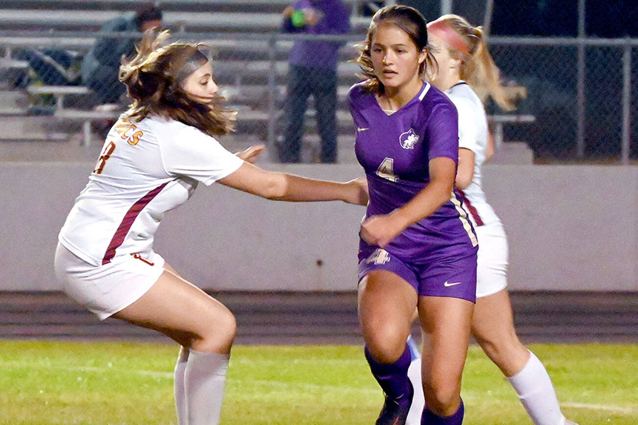 Michael Dashiell/Olympic Peninsula News Group
Sequim's Raimey Brewer looks forward after outmaneuvering Kingston's Emma Matteson for the ball during the Wolves' 4-0 win Tuesday.