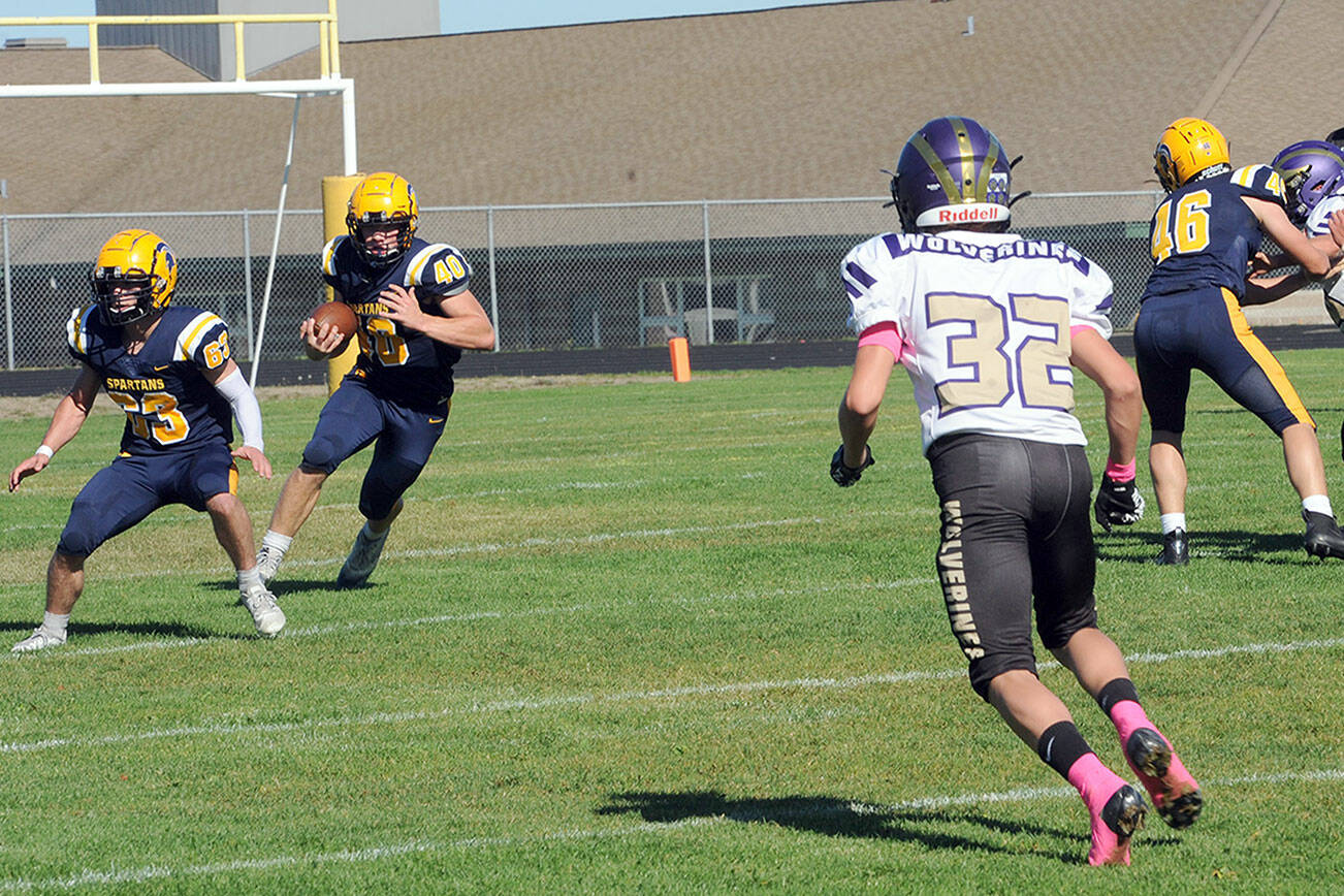 With Spartans Walker Wheeler (63) and Brody Lausche (46) blocking, Forks running back Nate Dahlgren picks up good yardage against Friday Harbor in a non league game played Saturday afternoon in Sequim.  Photo by Lonnie Arachibald.