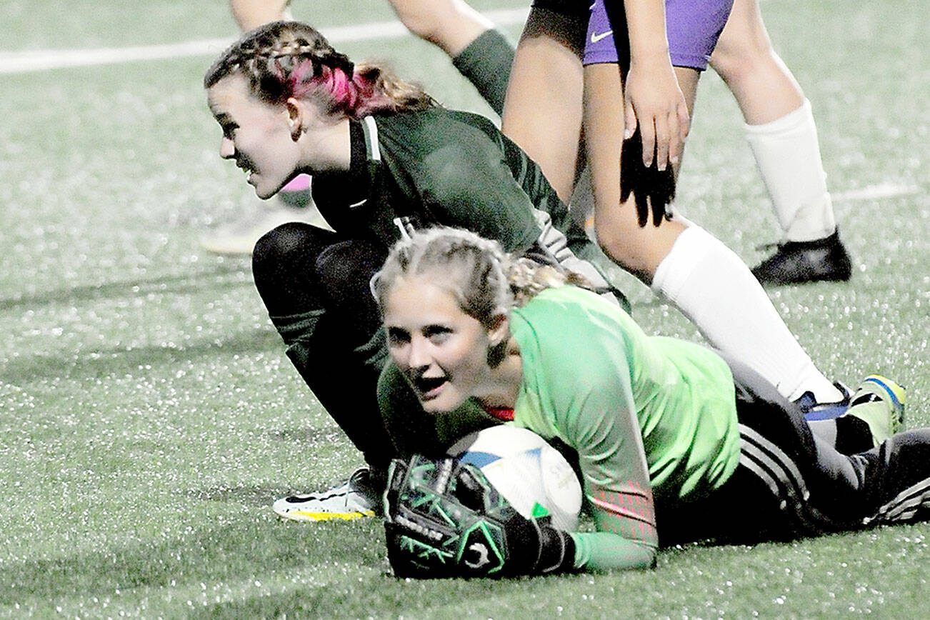 KEITH THORPE/PENINSULA DAILY NEWS
Sequim goalkeeper Kalli Grove clutches the ball after withstanding a shot by Port Angeles' Pyper Alton, lower left, and is assisted by teammate Amara Gonzalez, center, on Tuesday in Port Angeles.
