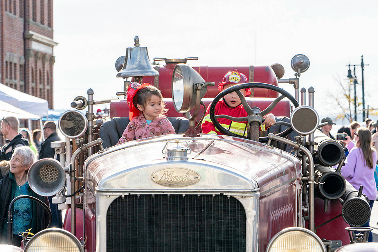 Kalila Skipper and Lucas Luong, both 4 and from Port Townsend, try the seats in Port Townsend’s oldest fire truck, a 1929 Mack that was on display during the East Jefferson Fire and Rescue Fest on Saturday in downtown Port Townsend as the service celebrates the 151st anniversary of its establishment. (Steve Mullensky/for Peninsula Daily News)