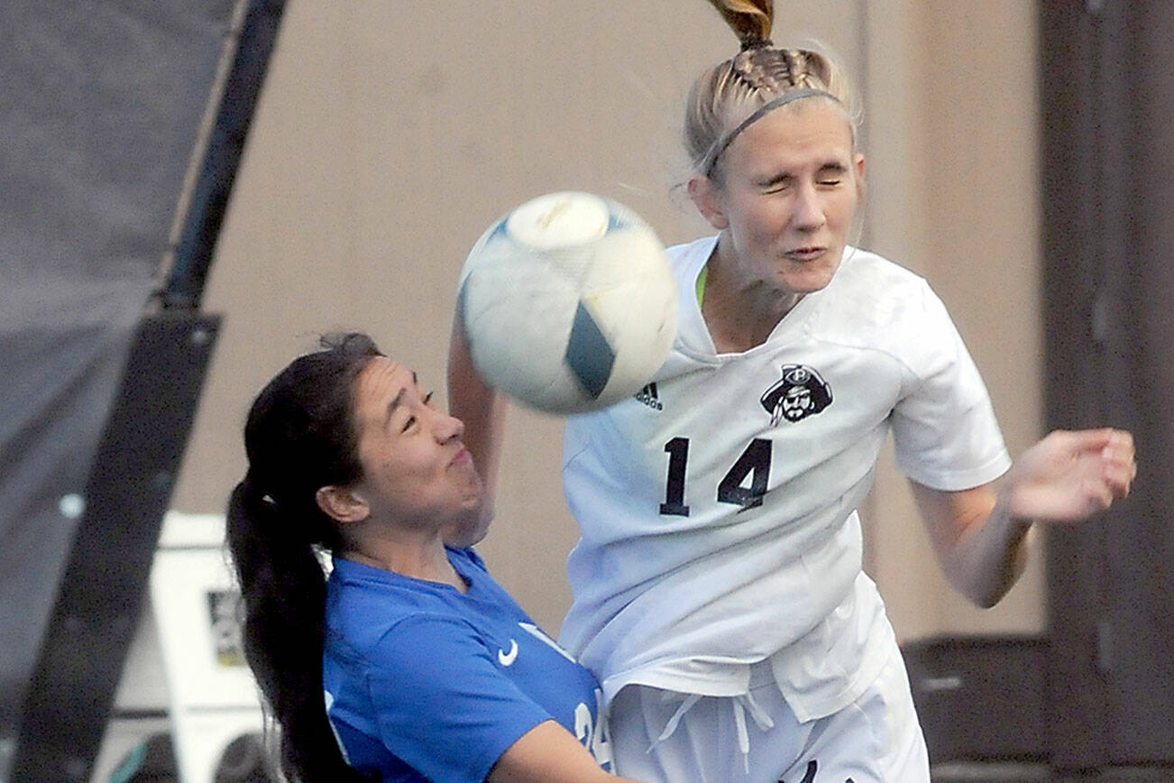 Peninsula’s Hannah Wagner deflects a header intended for Edmond’s Jennifer Wall Delamora during Wednesday’s match at Wally Sigmar Field. (Keith Thorpe/Peninsula Daily News)
