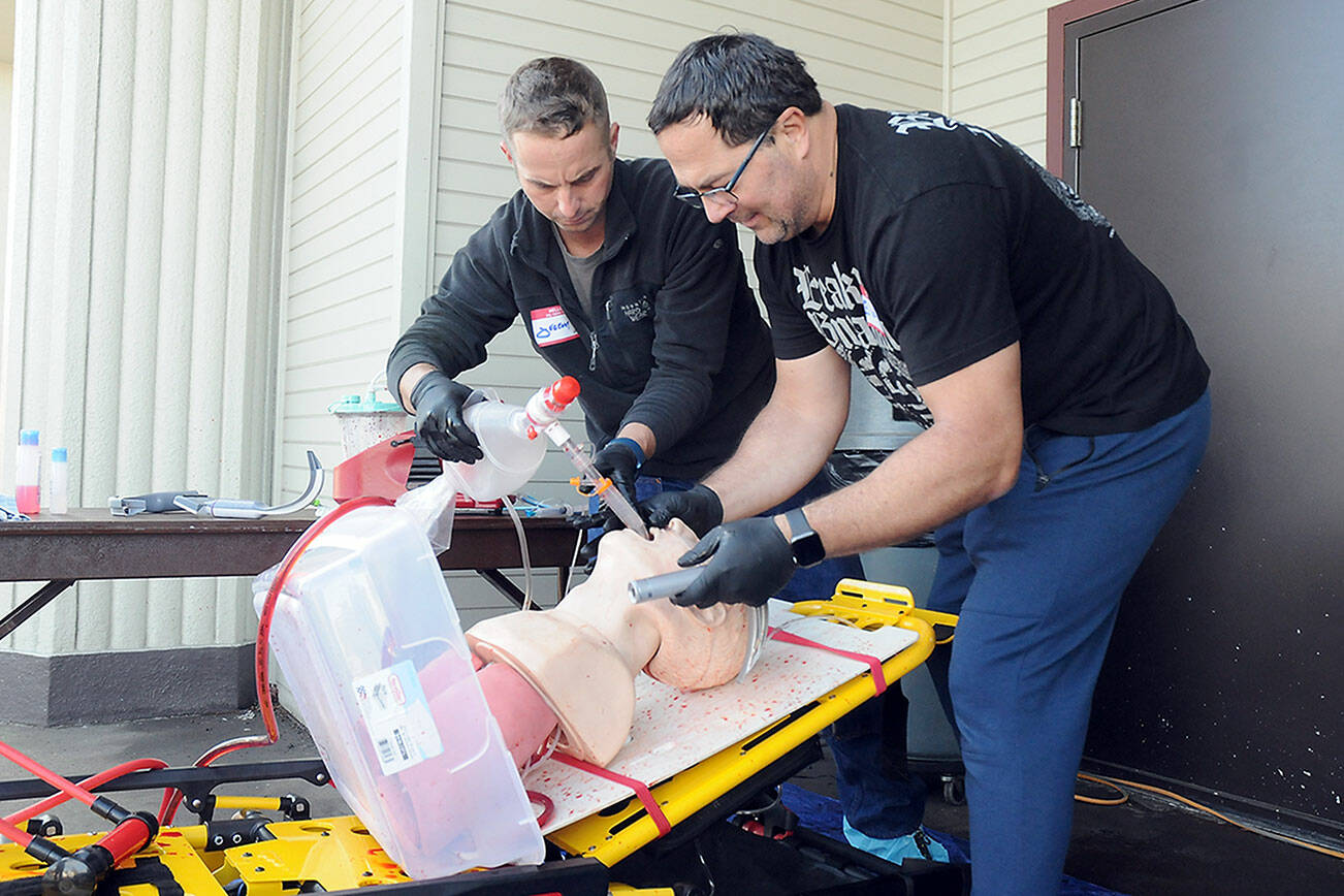 Clallam County Fire District 3 firefighter/paramedics Jeremy Church, left, and Jeff Albers practice resuscitation techniques during a training session on Thursday at Vern Burton Community Center in Port Angeles. Numerous medical personnel from fire districts 2, 3 and 4, along with the Port Angeles Fire Department and Olympic Ambulance, took part in the “Difficult Airway Course” featuring a variety of resuscitation situations in an event hosted by the Clallam County EMS Council. (Keith Thorpe/Peninsula Daily News)