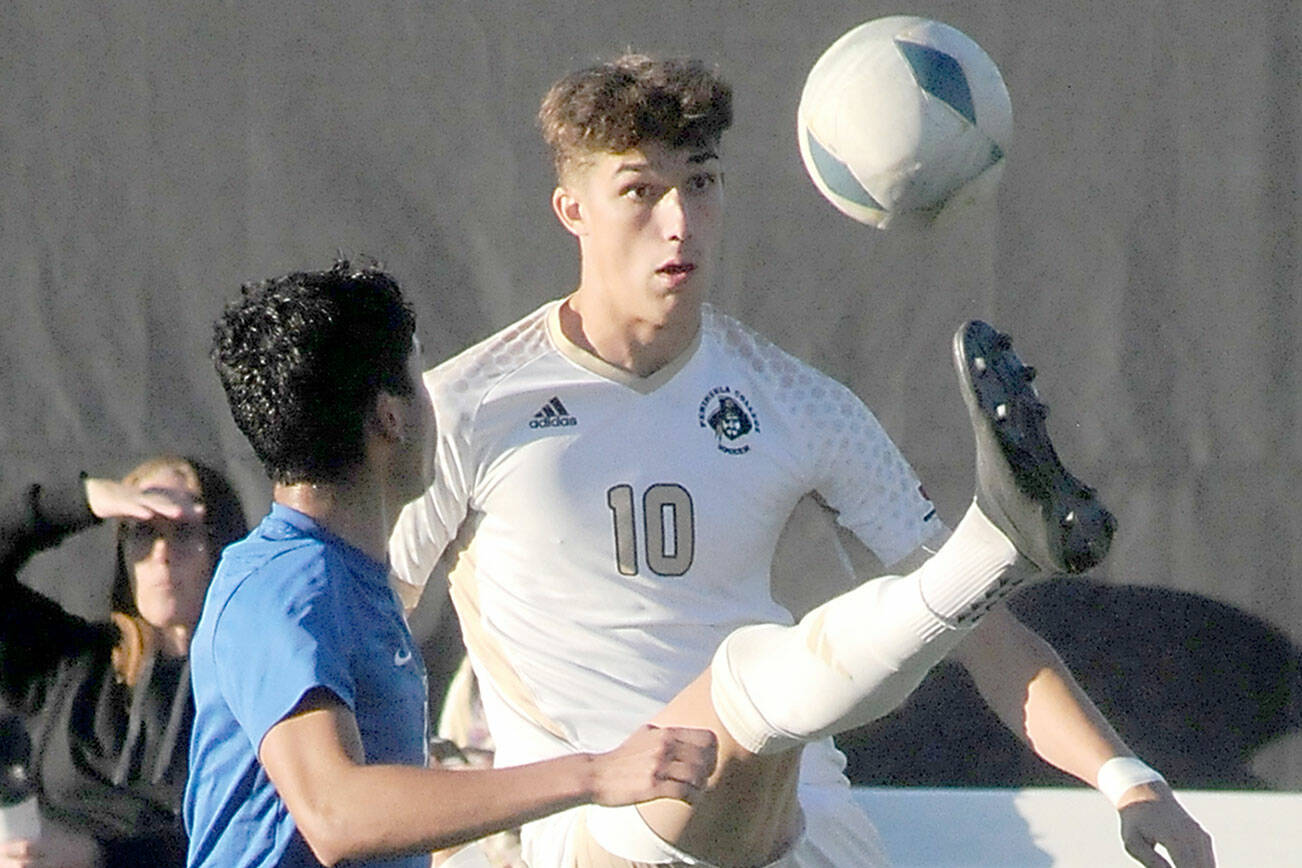 KEITH THORPE/PENINSULA DAILY NEWS
Peninsula's Nil Grau gives a high kick to keep the ball out of reach of Edmond's Enzo Buenaventura during Wednesday's match in Port Angeles.