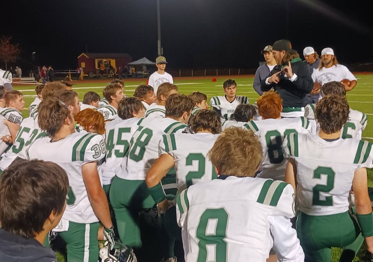 Coach Dustin Clark talks to his players after the Port Angeles Roughriders crushed Kingston 63-0 on Thursday night in Kingston. The Riders have all but locked up a playoff spot with one game remaining against North Mason. (Pierre LaBossiere/Peninsula Daily News)