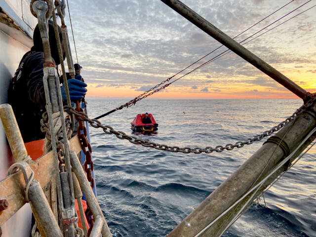 Good Samaritans aboard the Canadian fishing vessel Ocean Sunset approach the life raft. (Photo provided by U.S. Coast Guard)